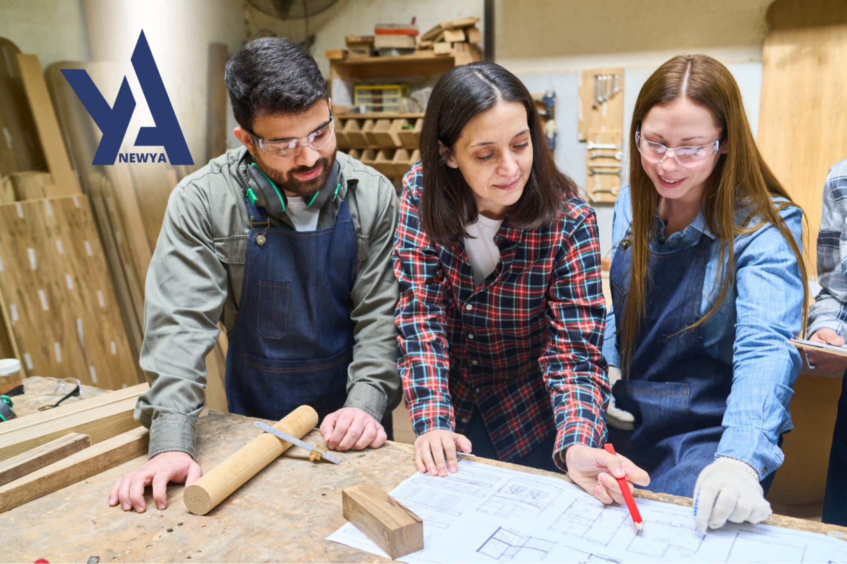 Two adults and one student standing at a drafing table looking at papers.