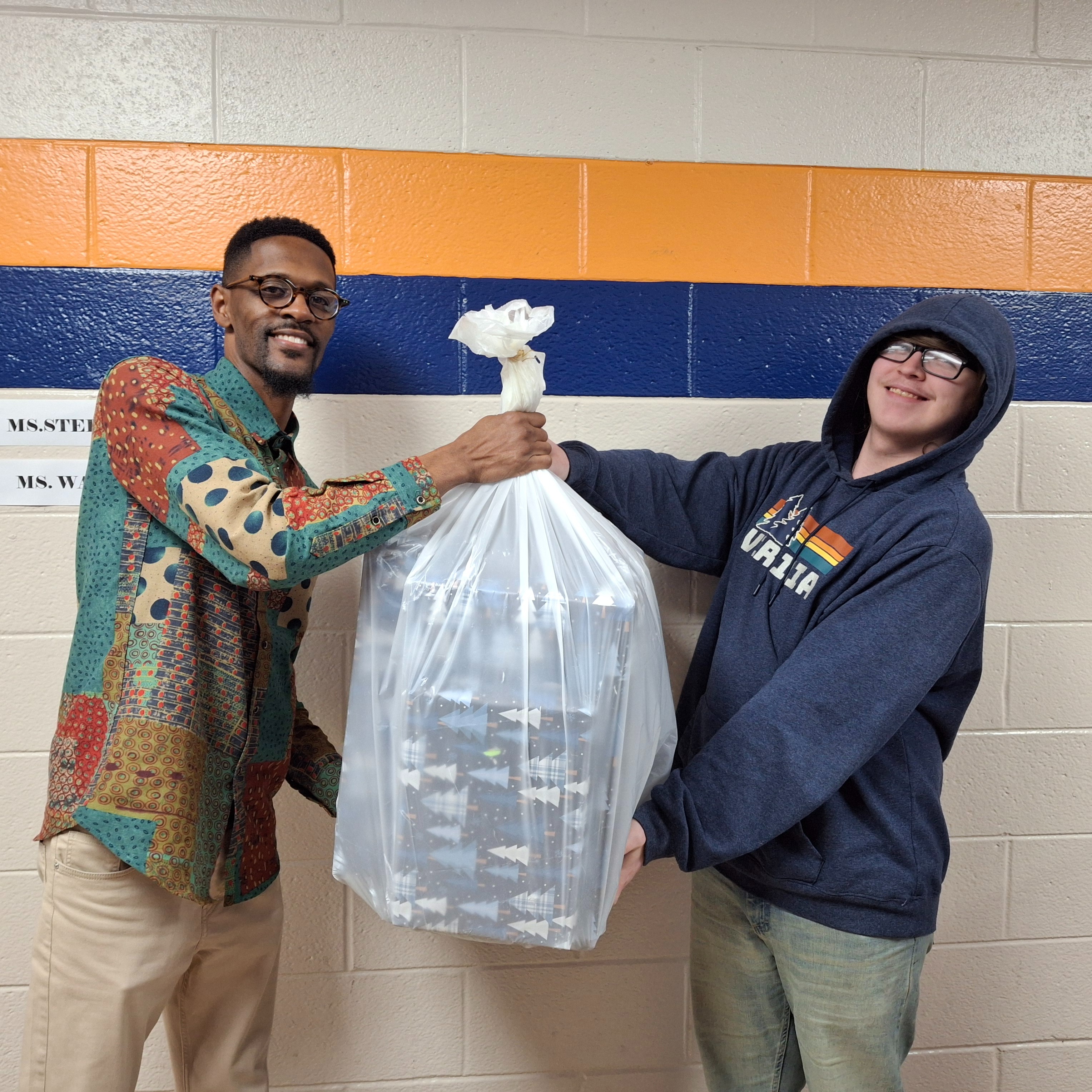 Mr. Brown handing Mason Mullins Christmas Presents