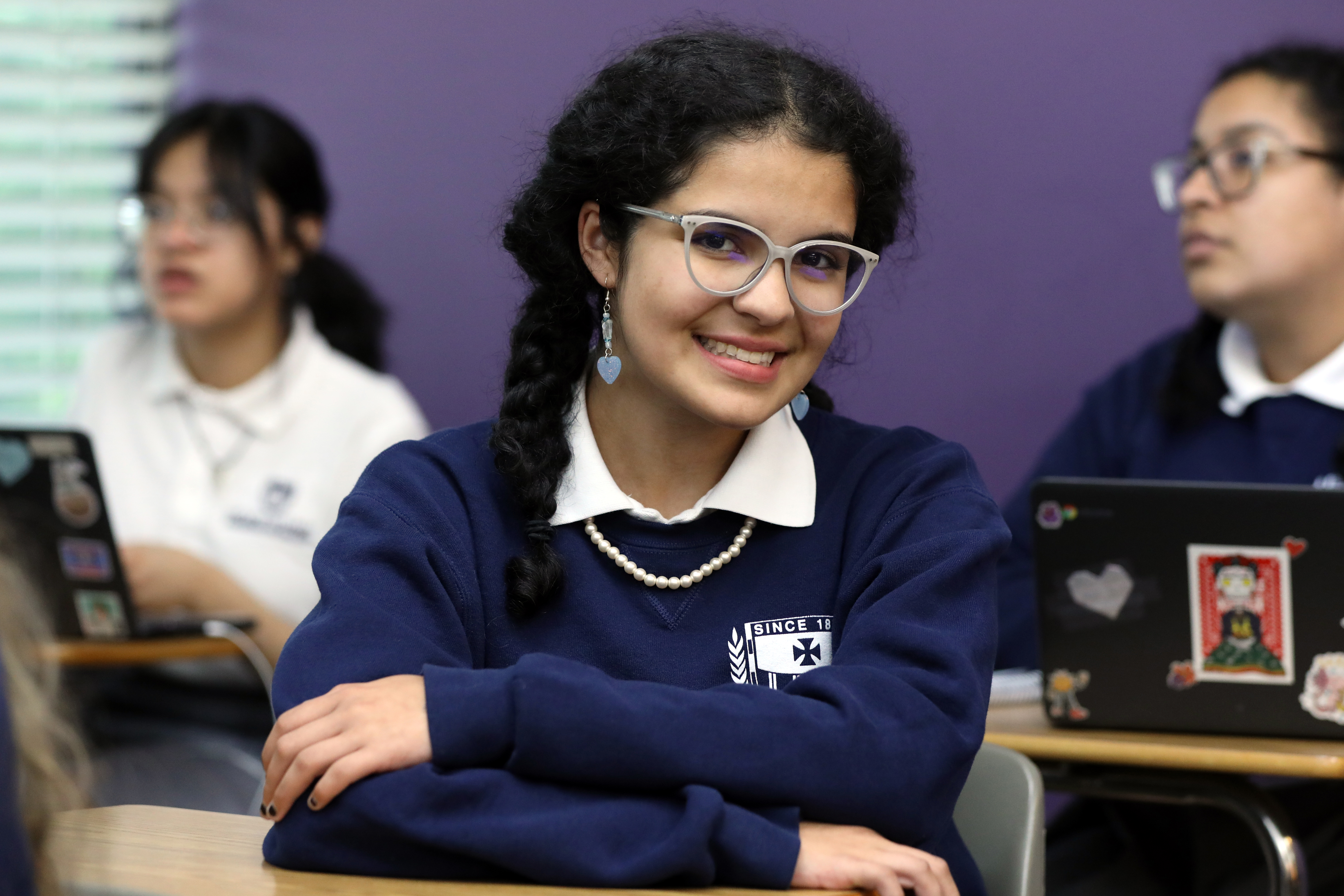 Image of student sitting at desk and smiling