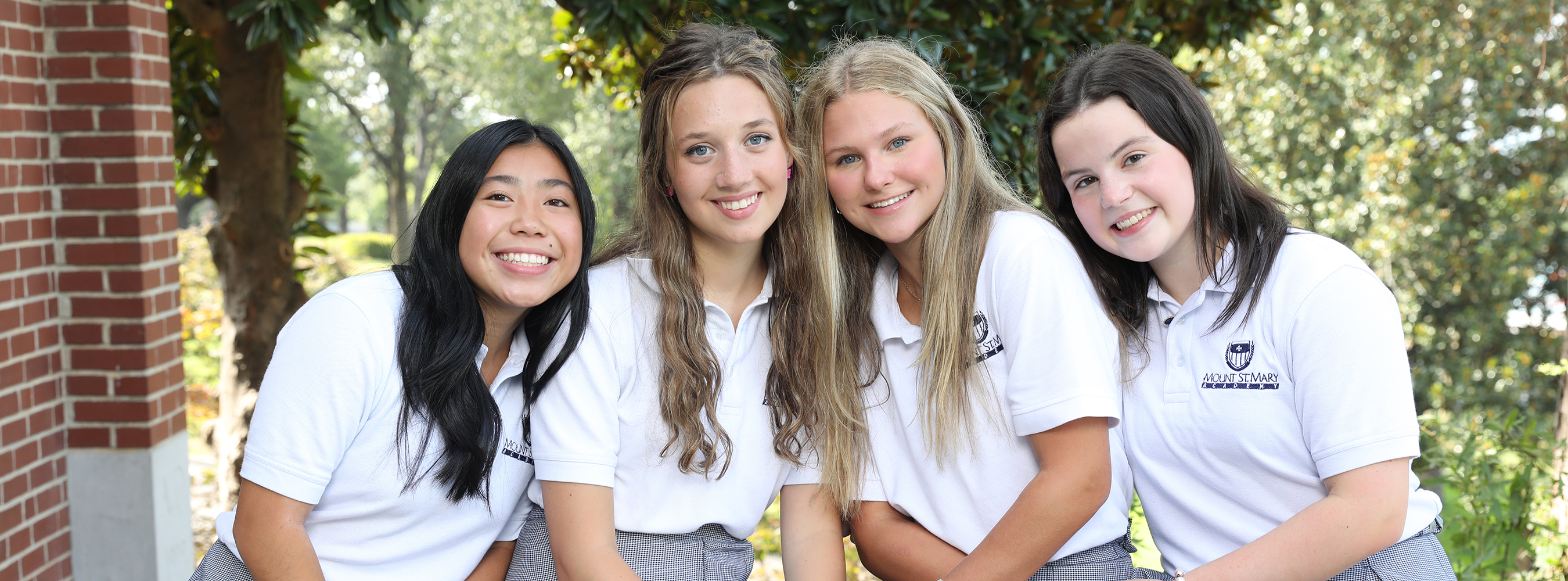 group of four smiling students