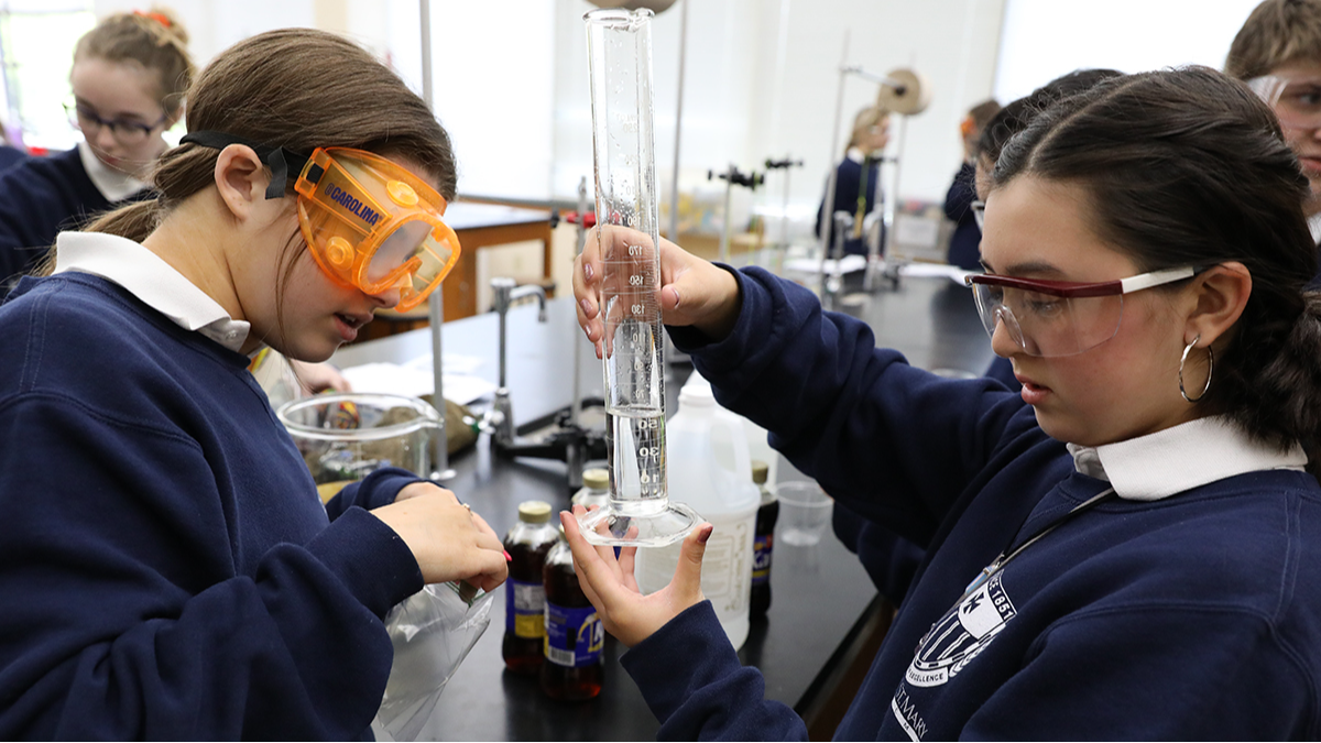two students in science lab completing an experiment