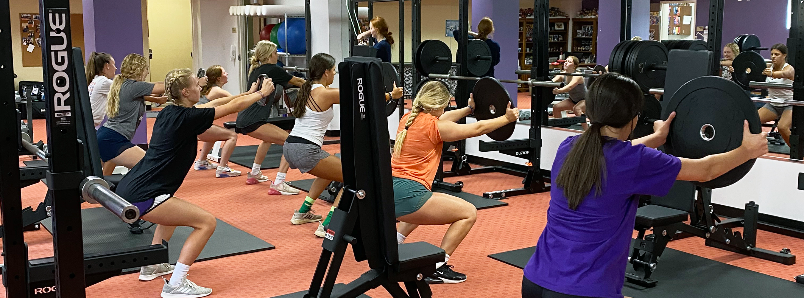group of student-athletes lifting weights