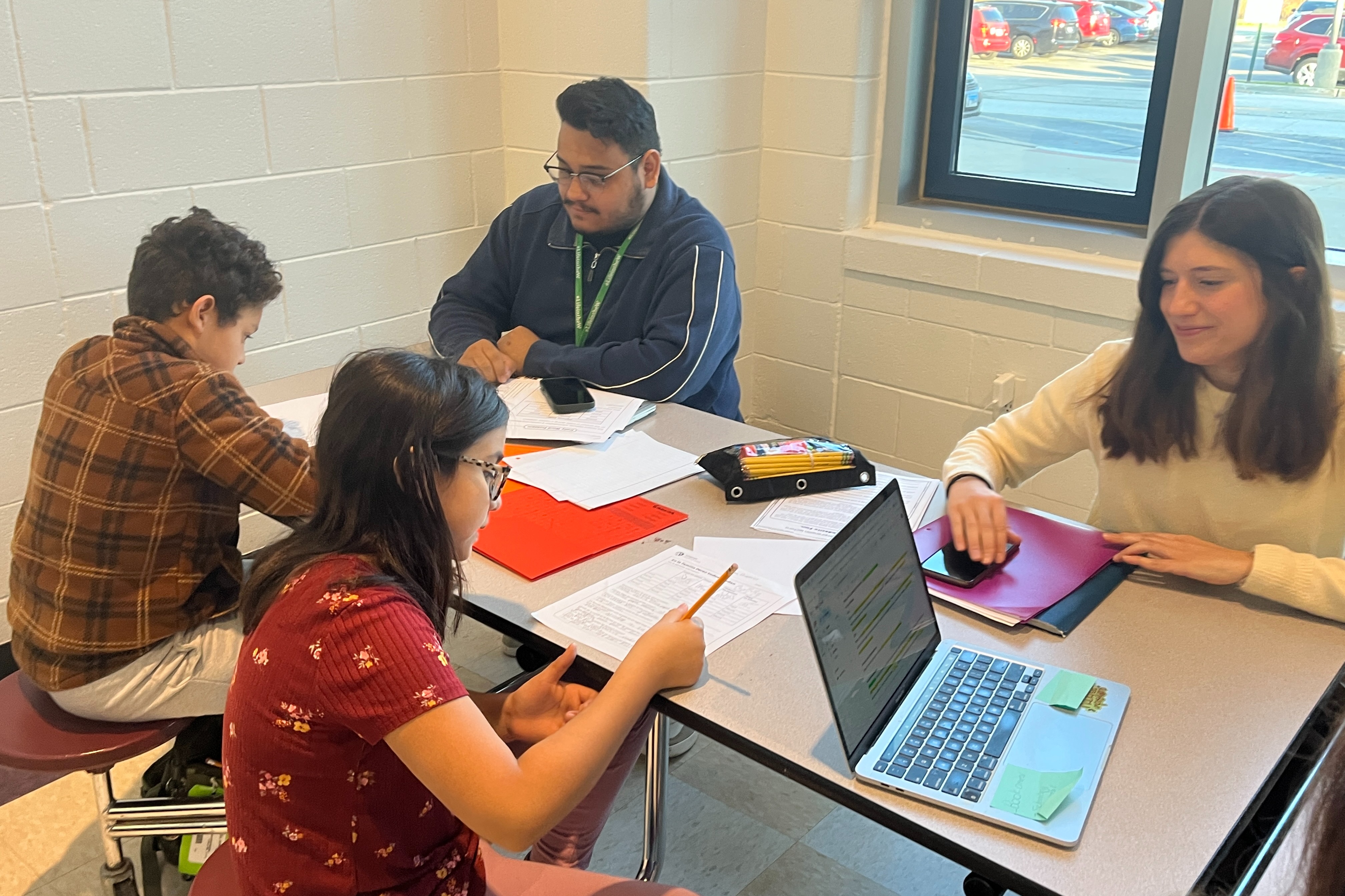 Students working with teacher for homework help