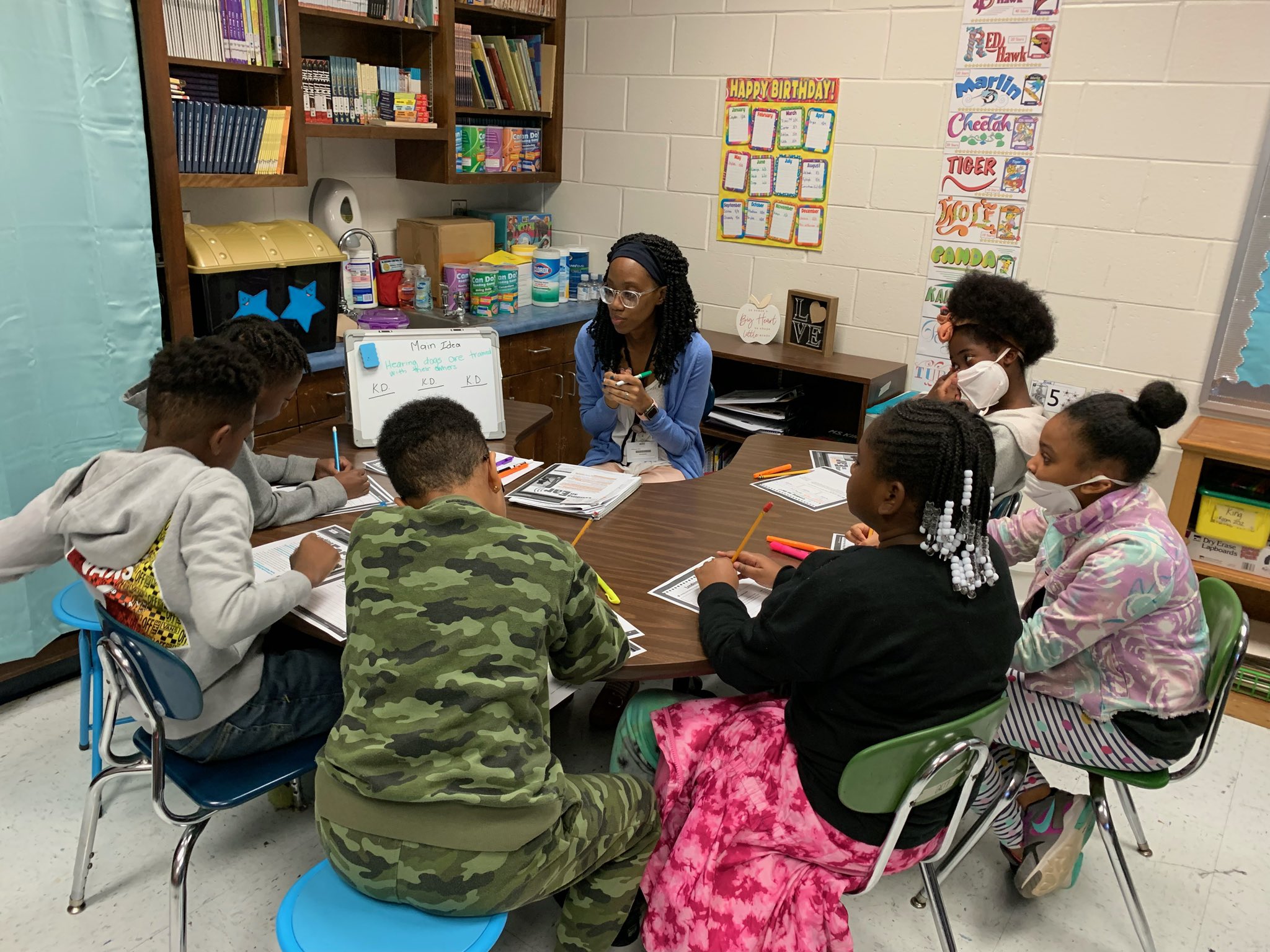 students with teacher at table