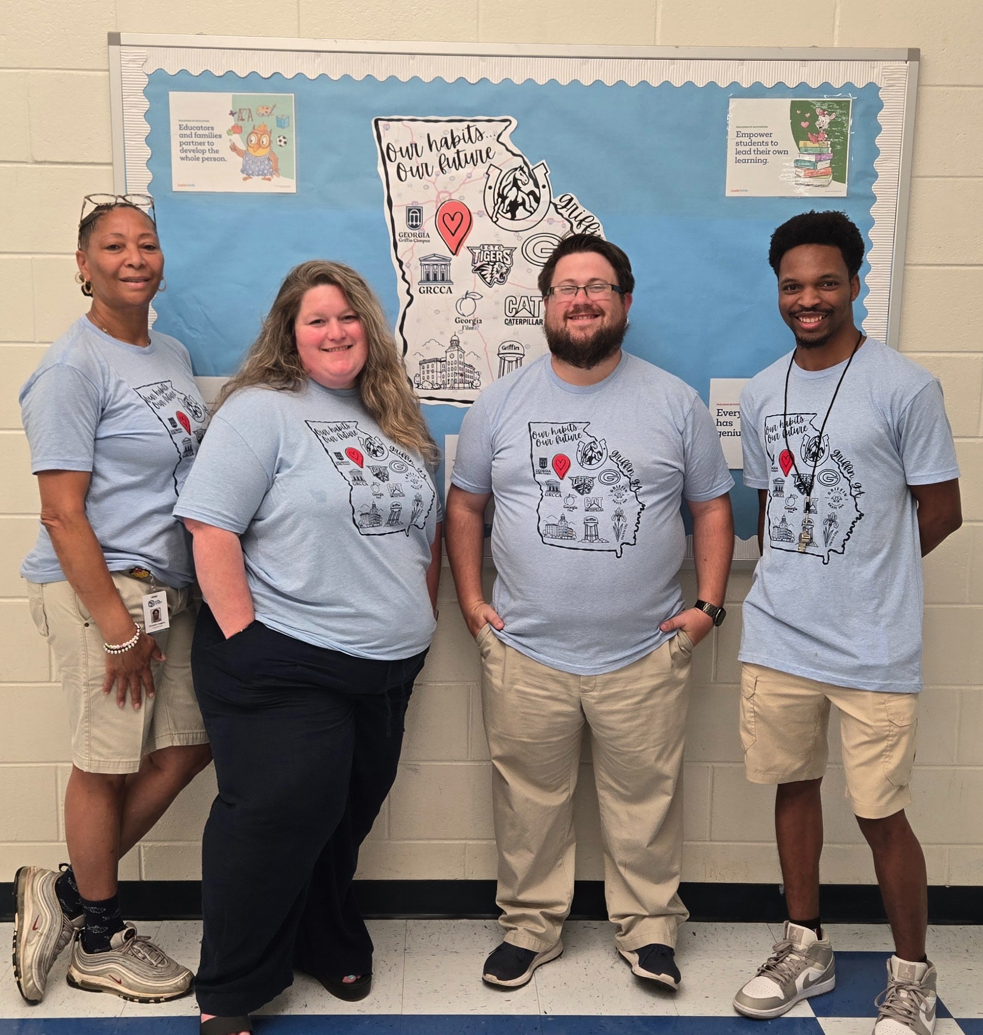 four adults standing in hall in blue Cowan shirts