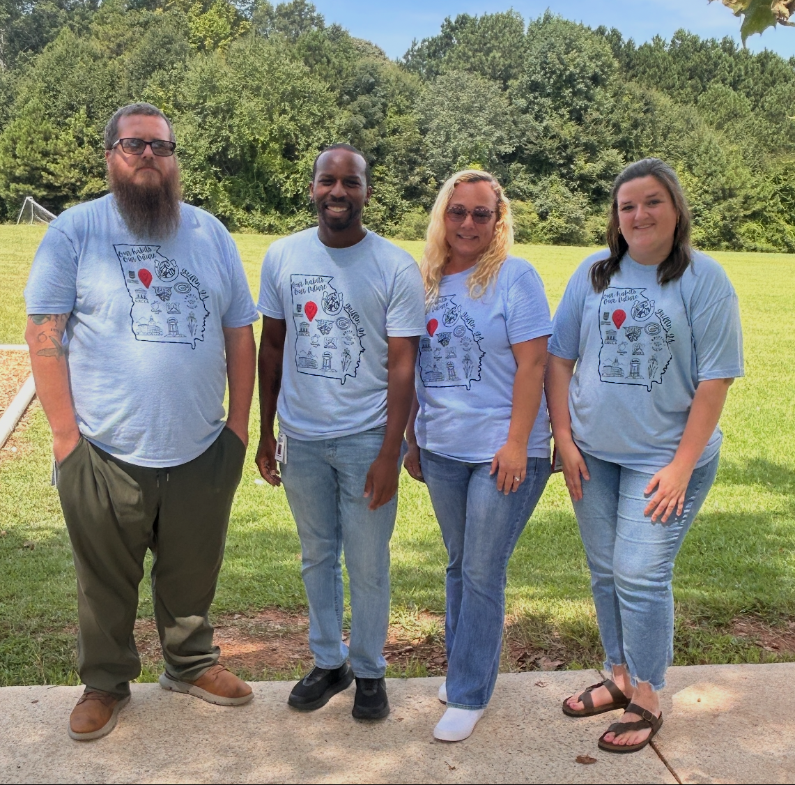 four adults in light blue shirts