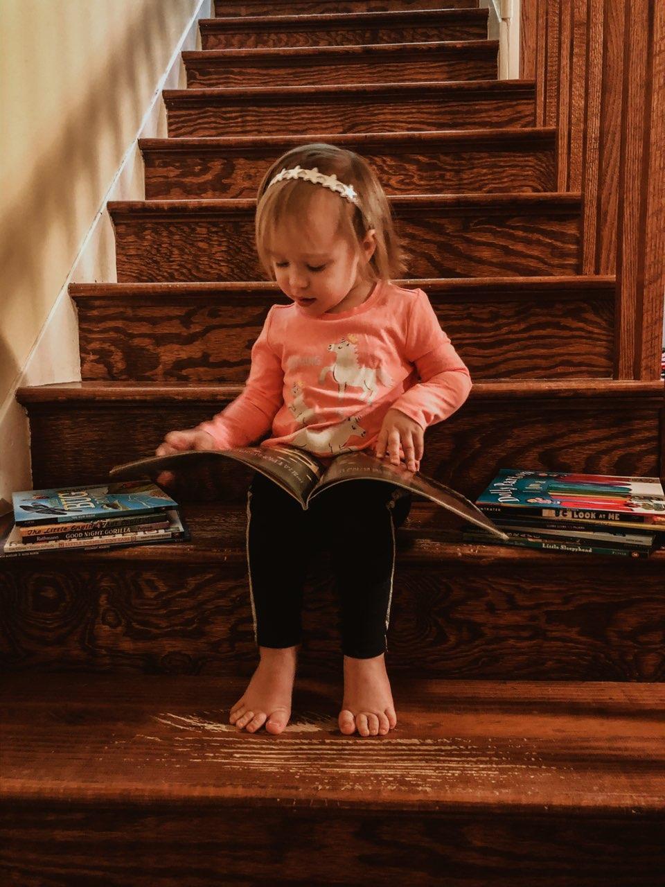 student reading a book on stairs