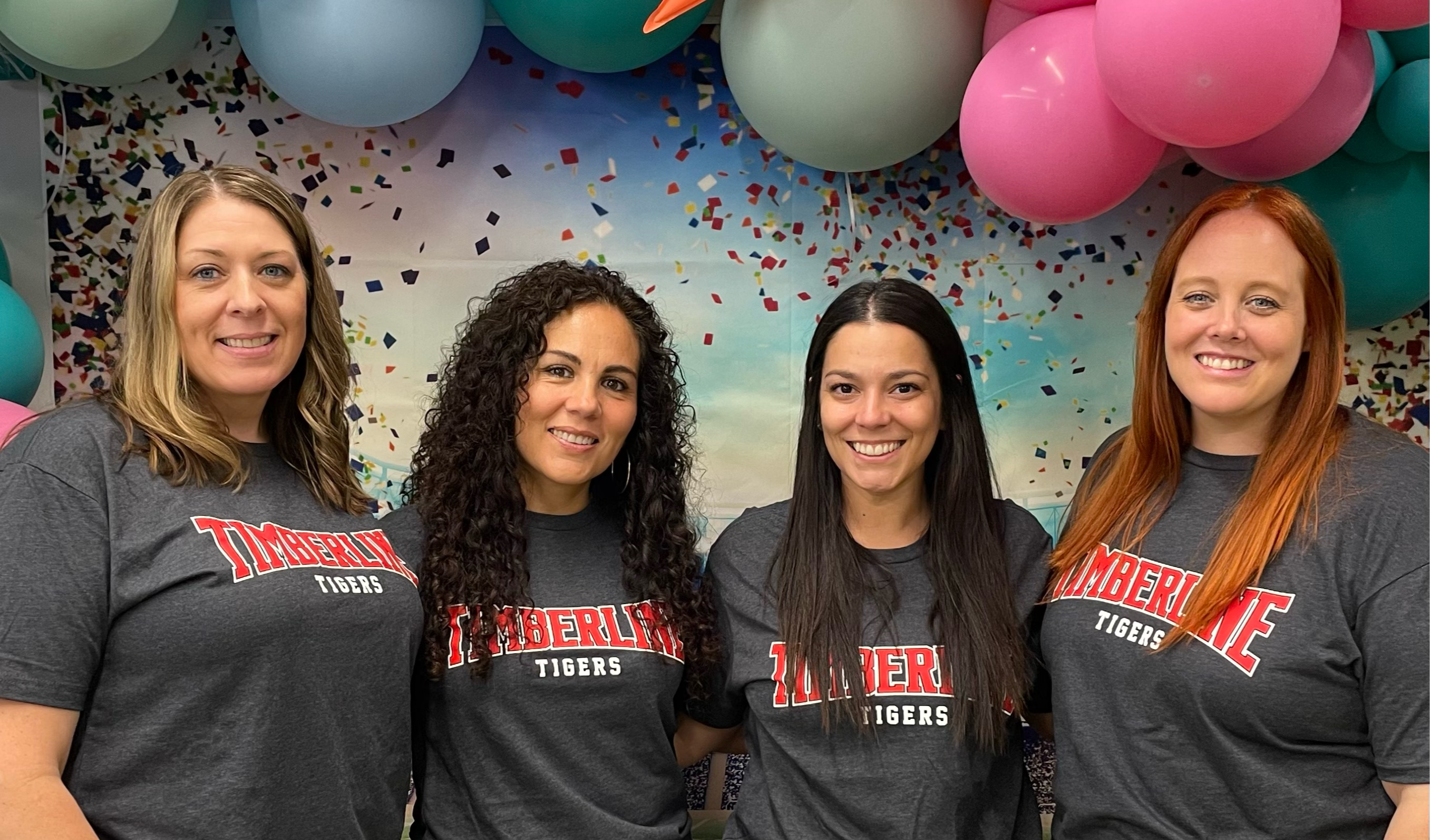 The kindergarten teachers pose in matching t-shirts.