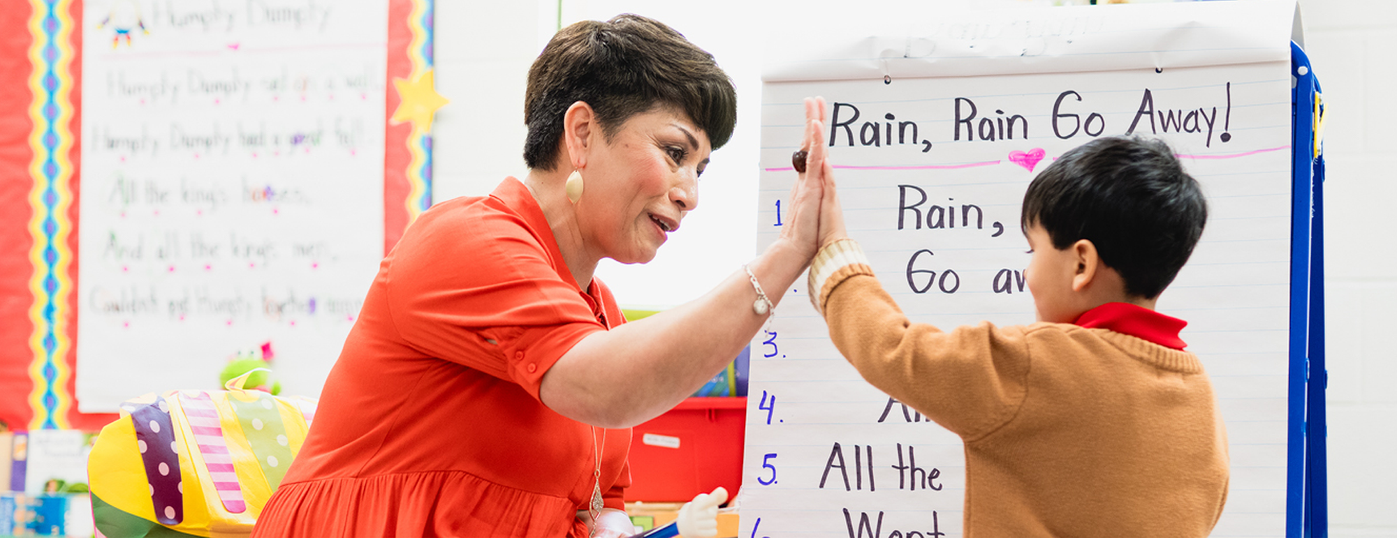 Teacher giving a student a high five for participating in an activity