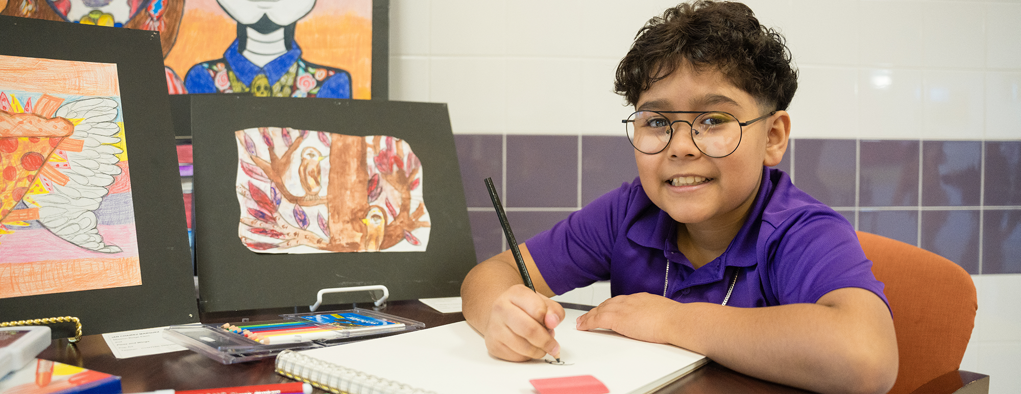 Student smiling while working on an art project