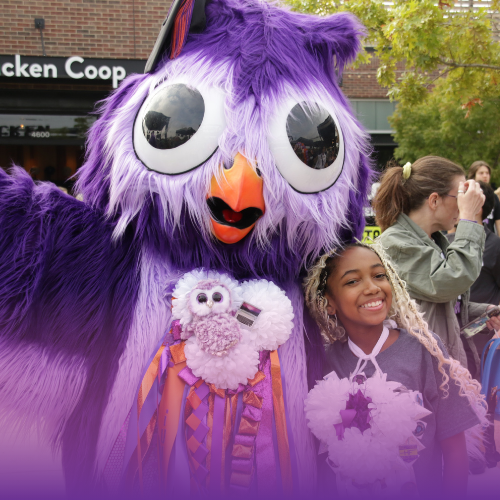 Owly mascot posing with a smiling student