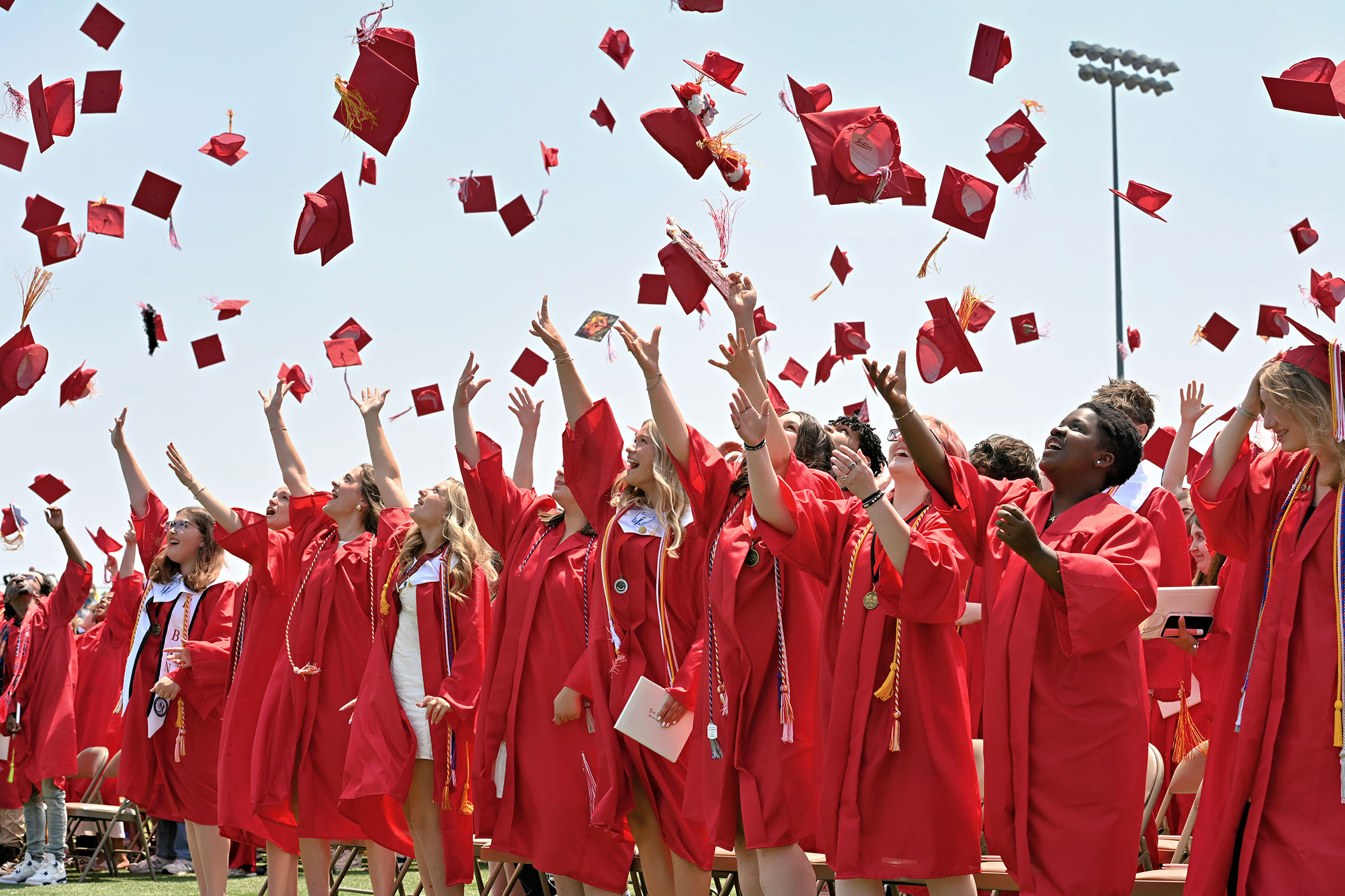 graduates tossing caps into air