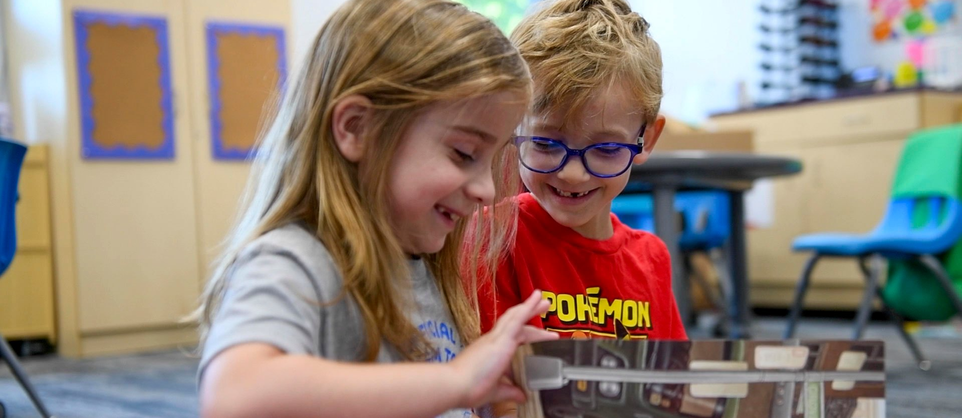 two students reading a book together