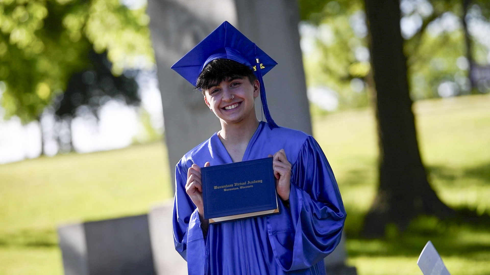 graduate smiling holding diploma