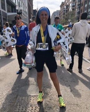 Gail Benjamin posing after marathon with medal