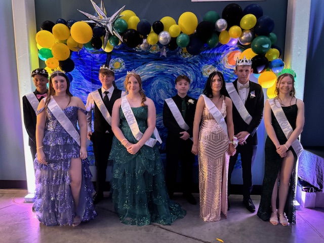 Prom court standing in front of starry night banner