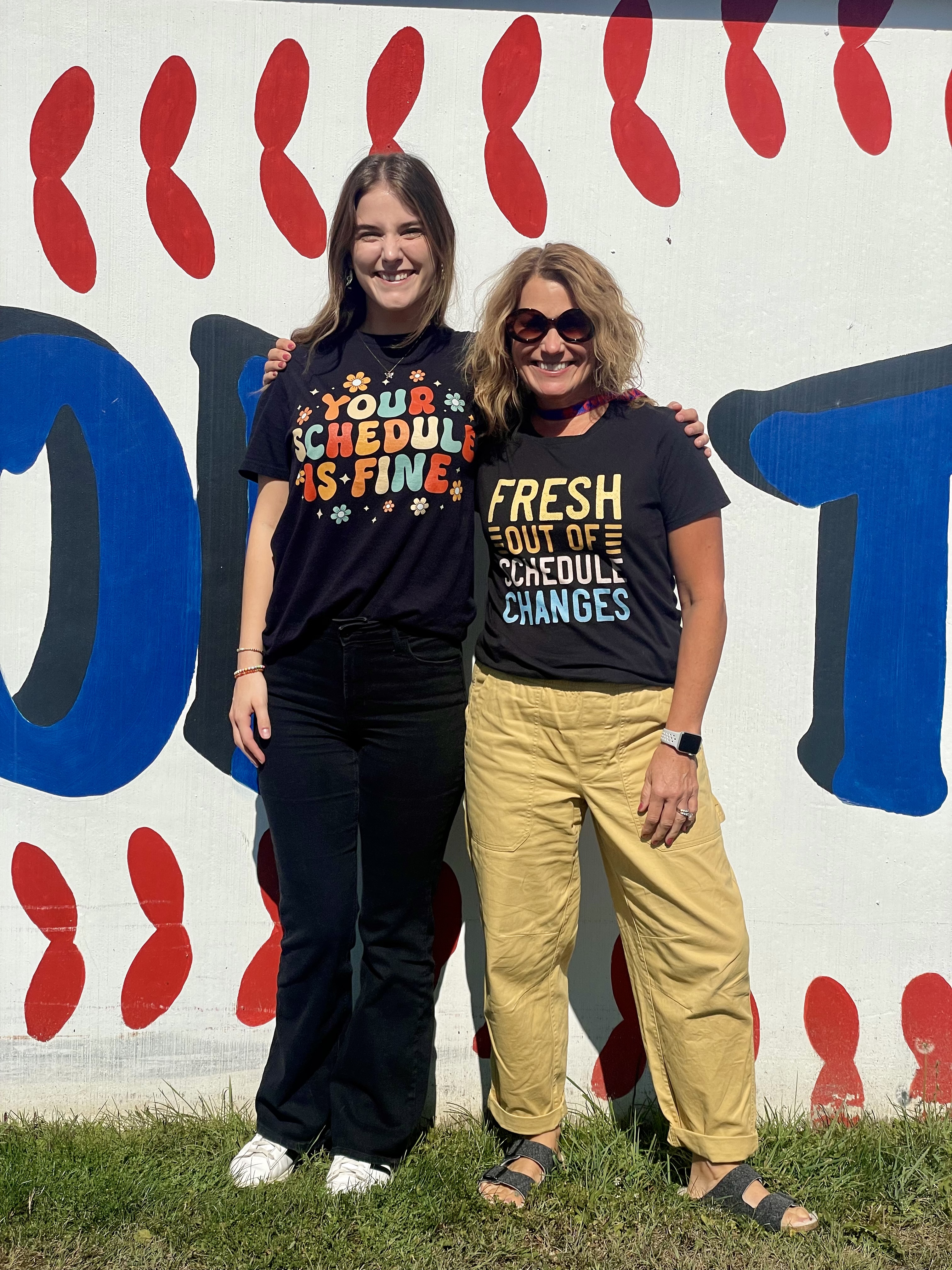 2 school counselours standing in front of Panther dugout
