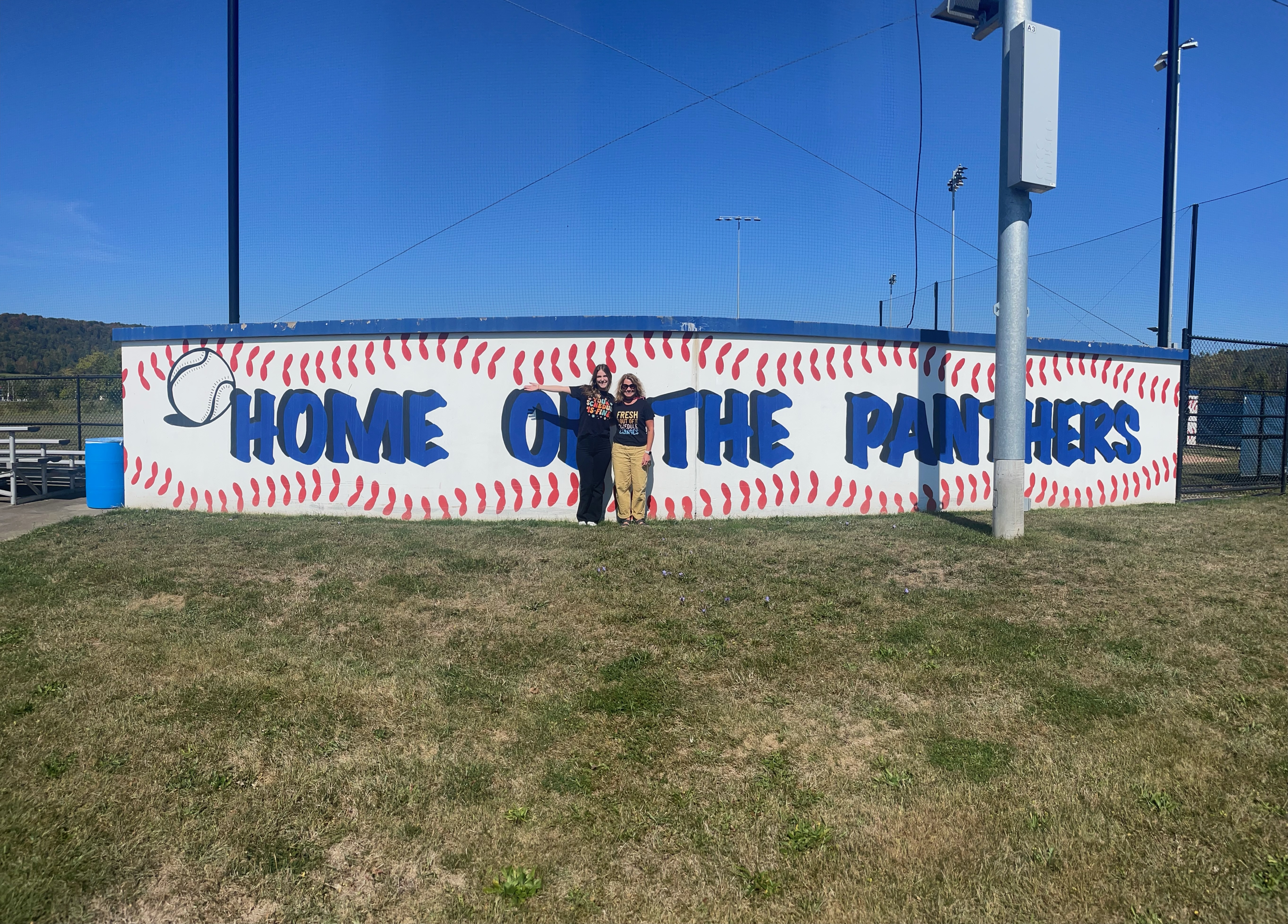 Large shot picture of 2 guidance counselors in front of the dugout
