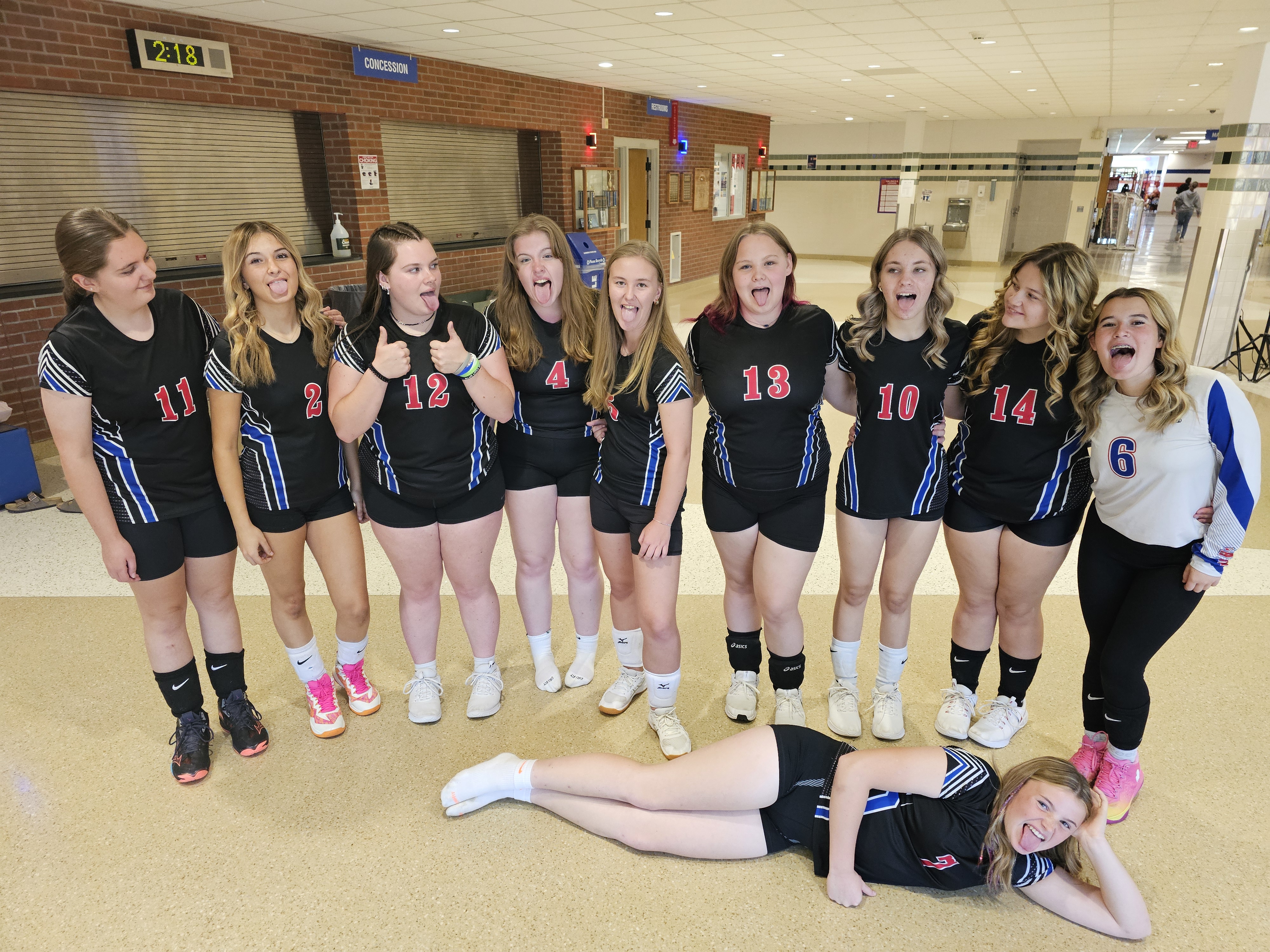 Students posing in black uniforms with goofy faces