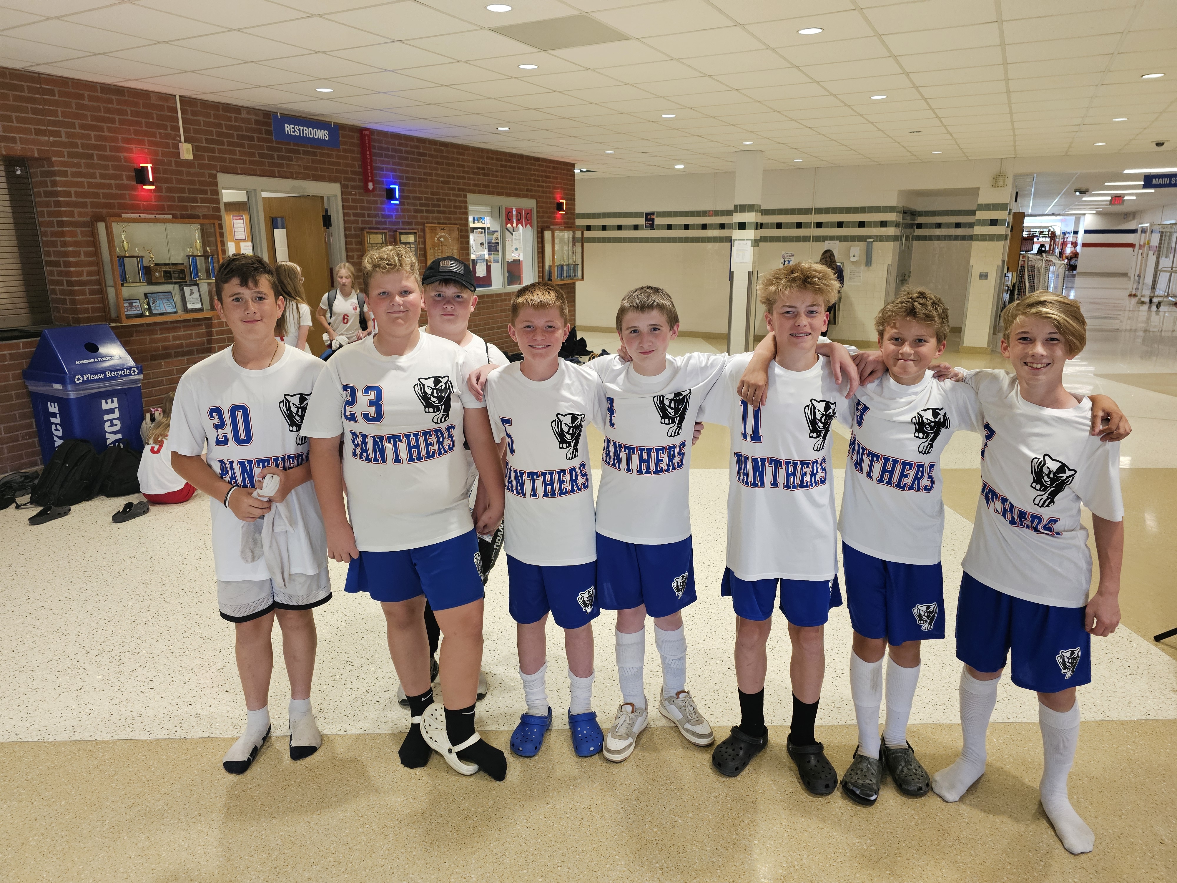 Soccer team posing with white and blue uniforms.