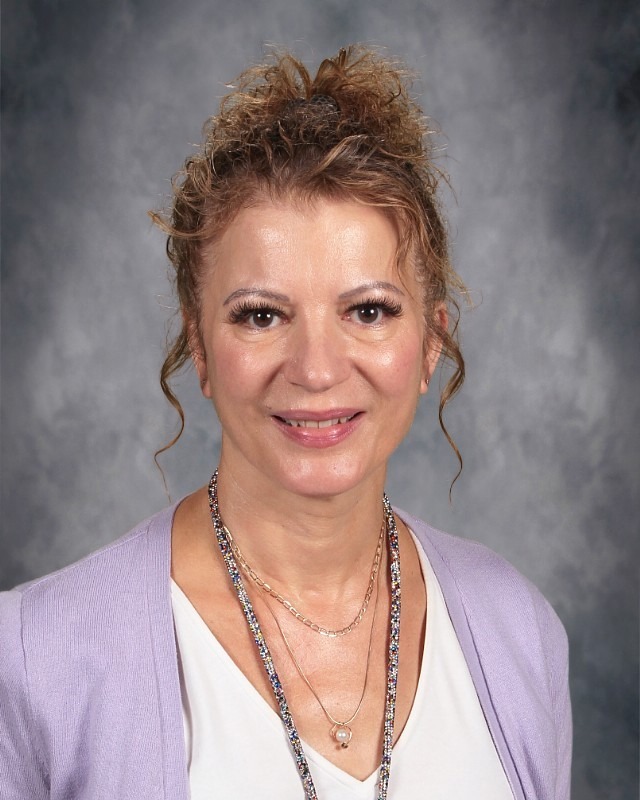 Teacher with curly brown hair smiling