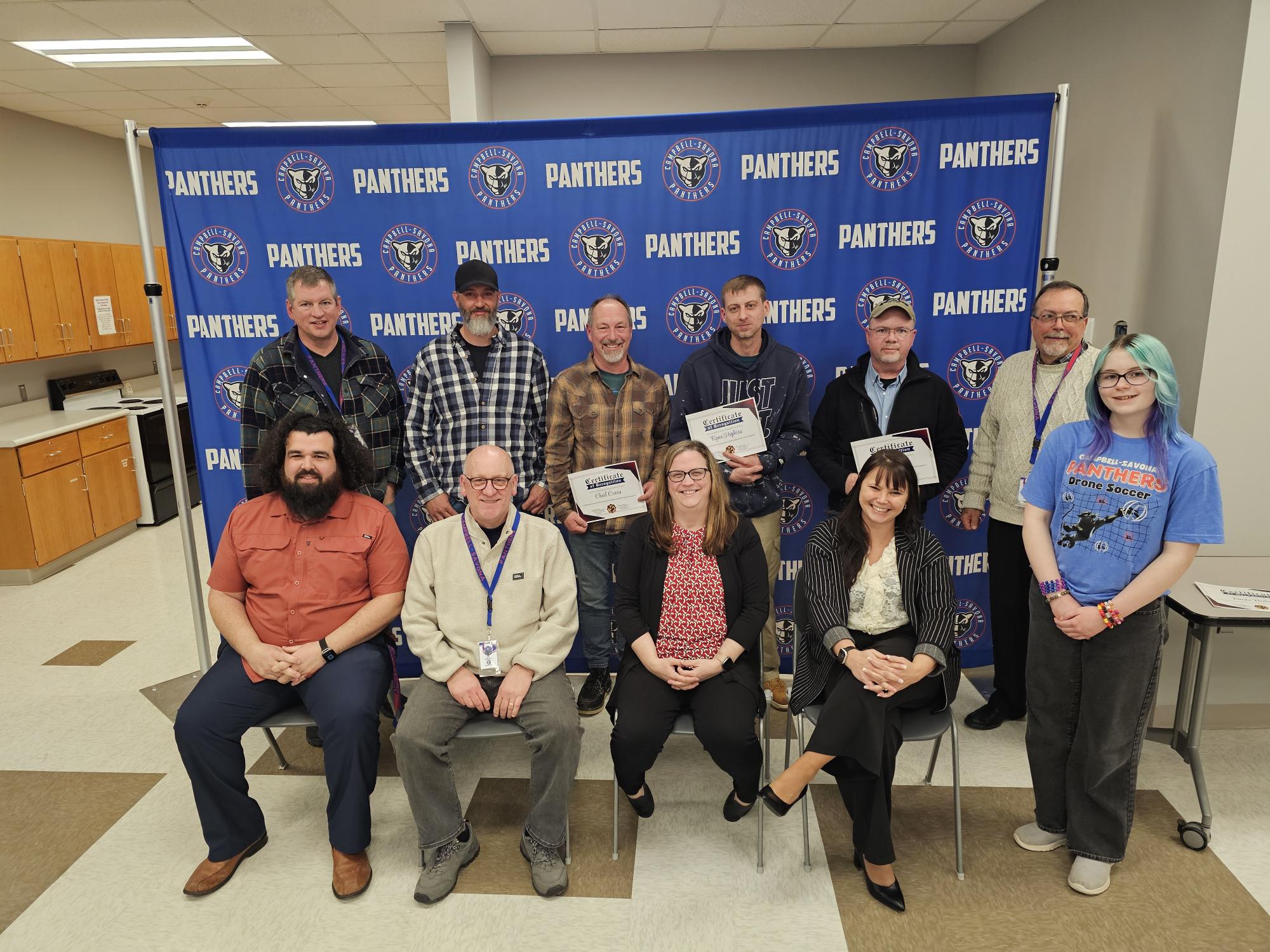 BOE in front of panther banner honoring maintenance workers