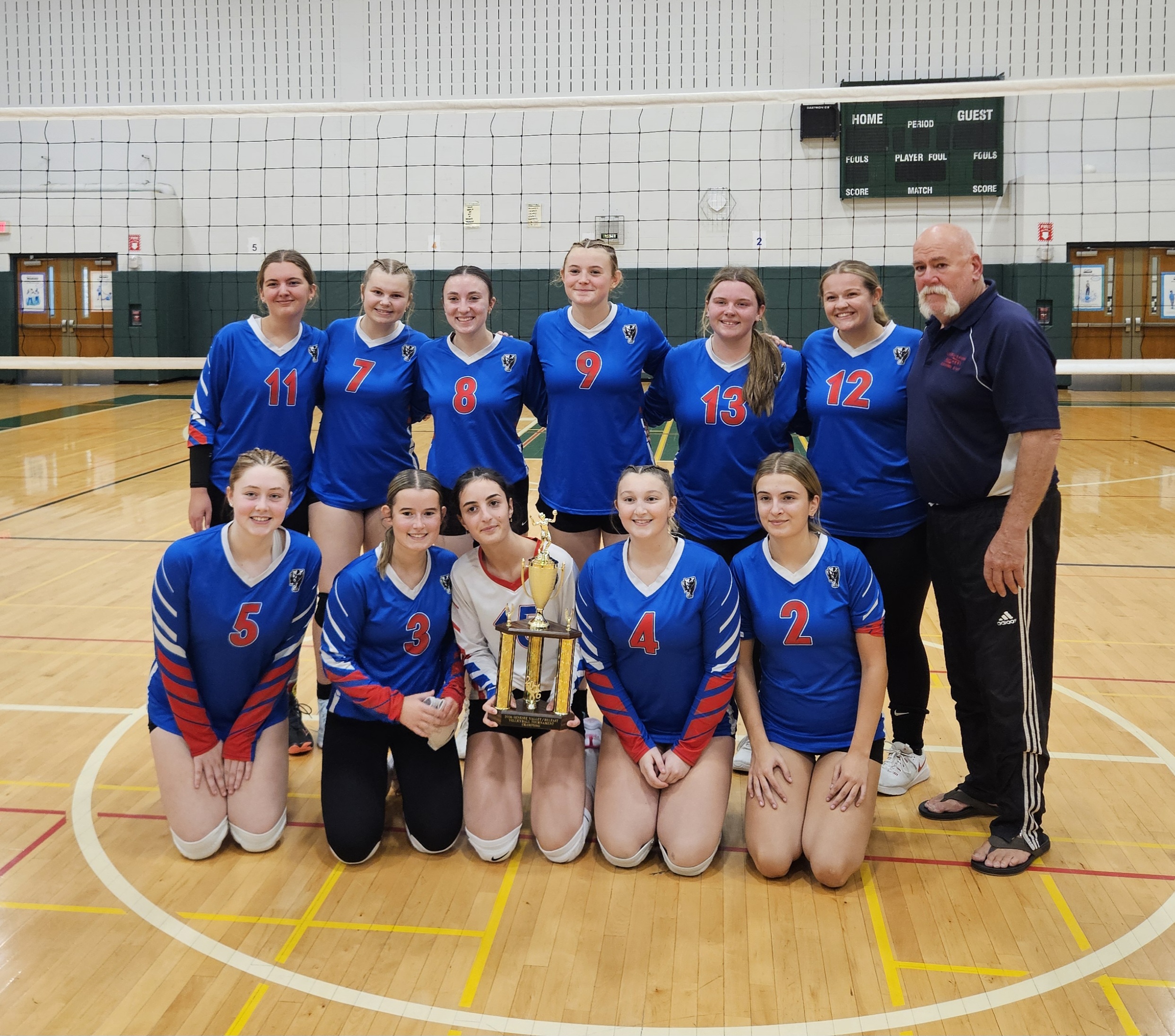 Volley ball team with trophy and blue uniforms