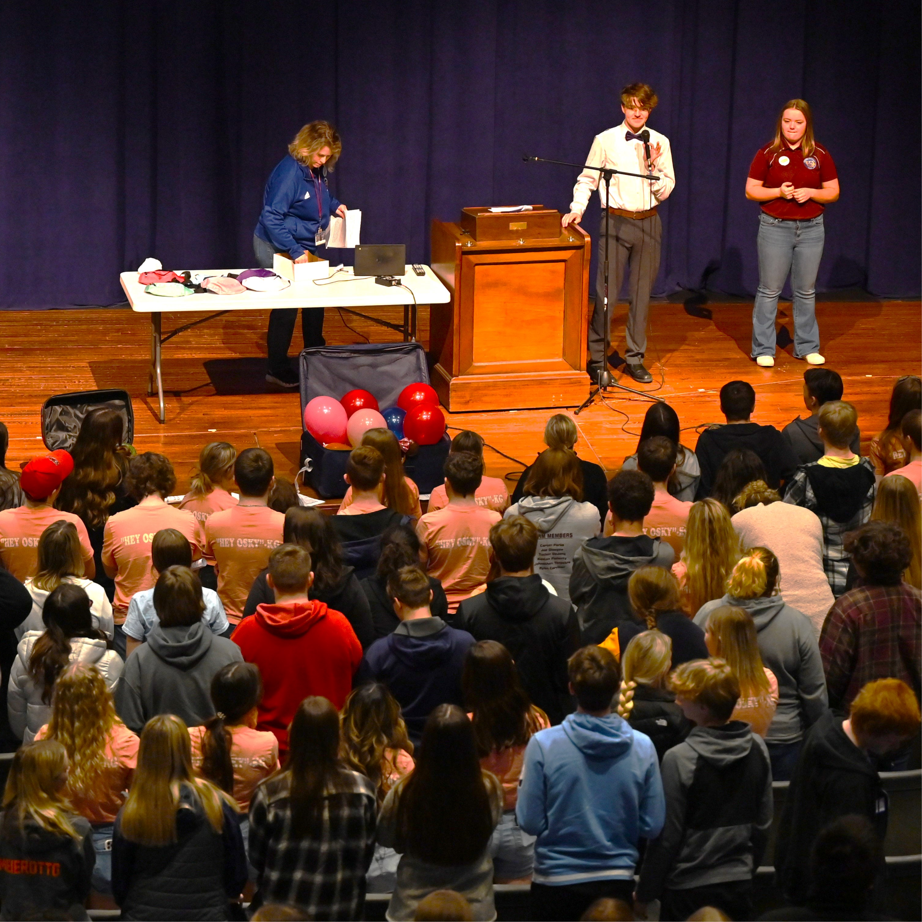 photo of student council students gathered with students speaking on a stage