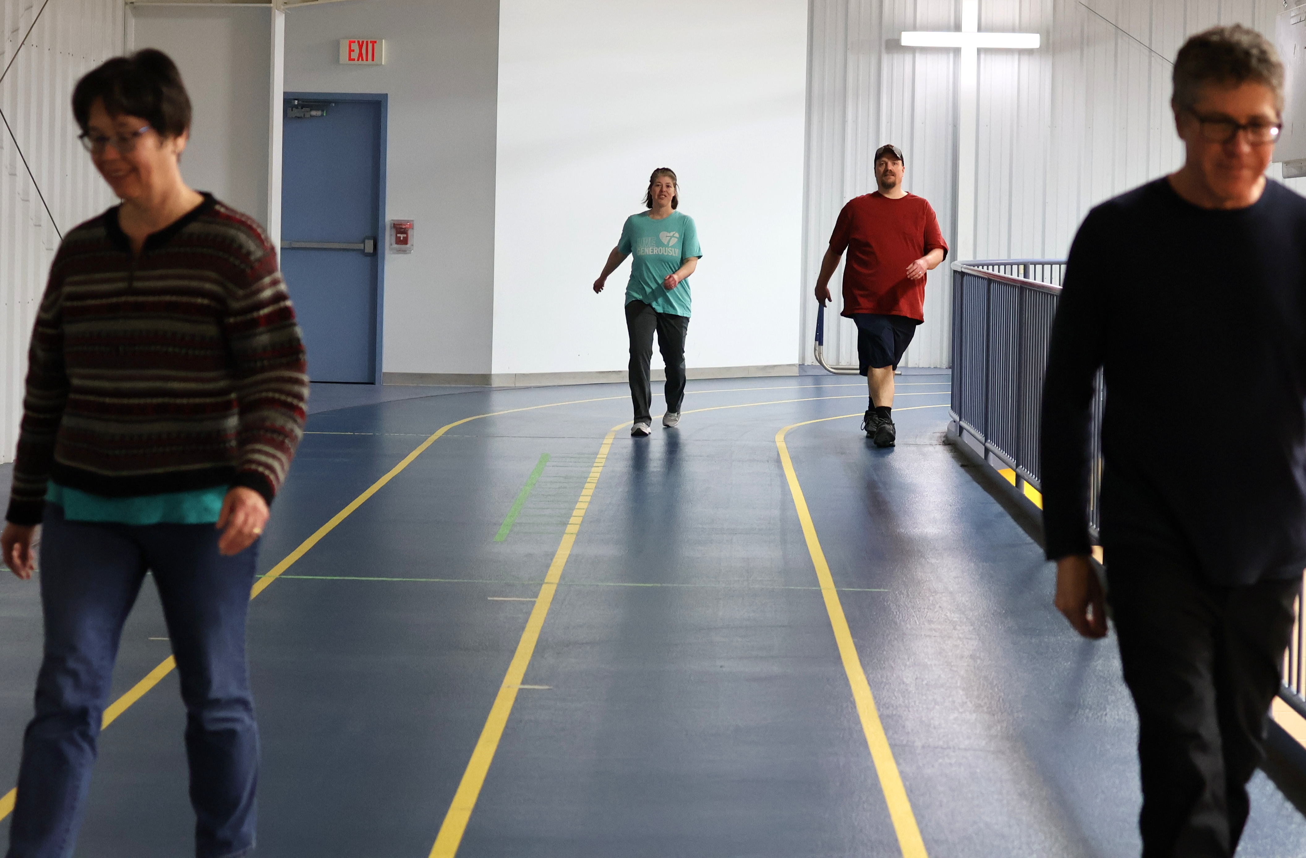 two people walk on an indoor track