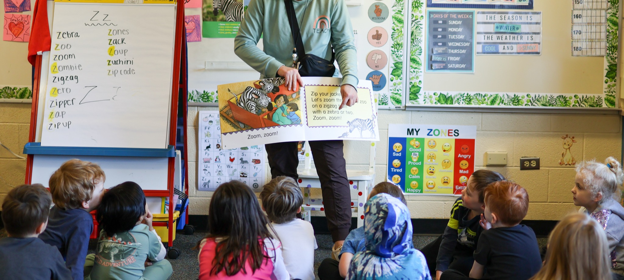 students listening to a teacher reading a book