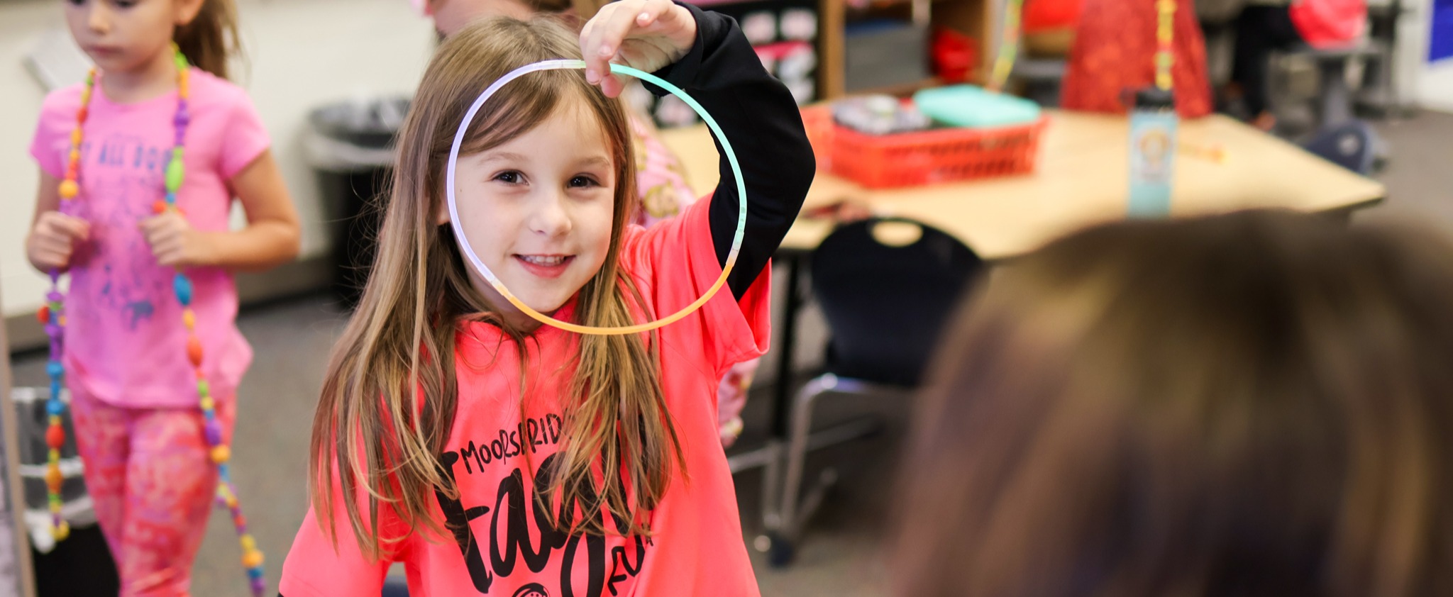 a girl holding a glow stick smiles for the camera