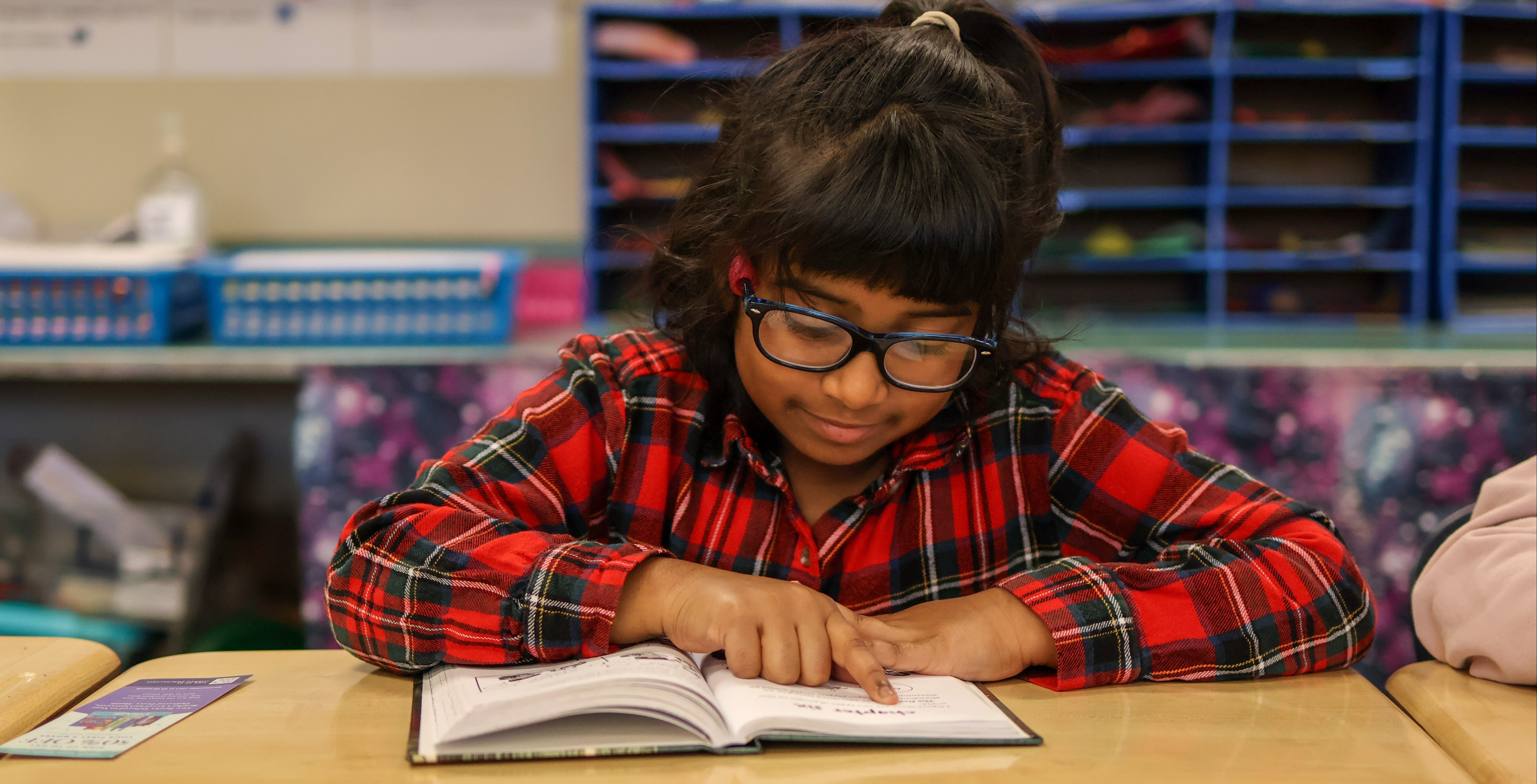 a girl reads a book in a classroom