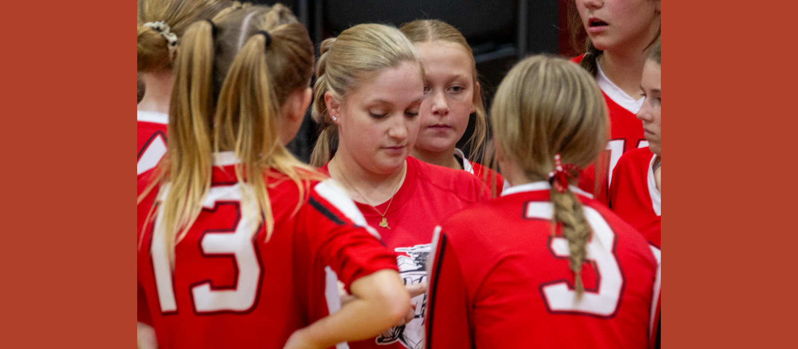 A volleyball coach talks to her team.