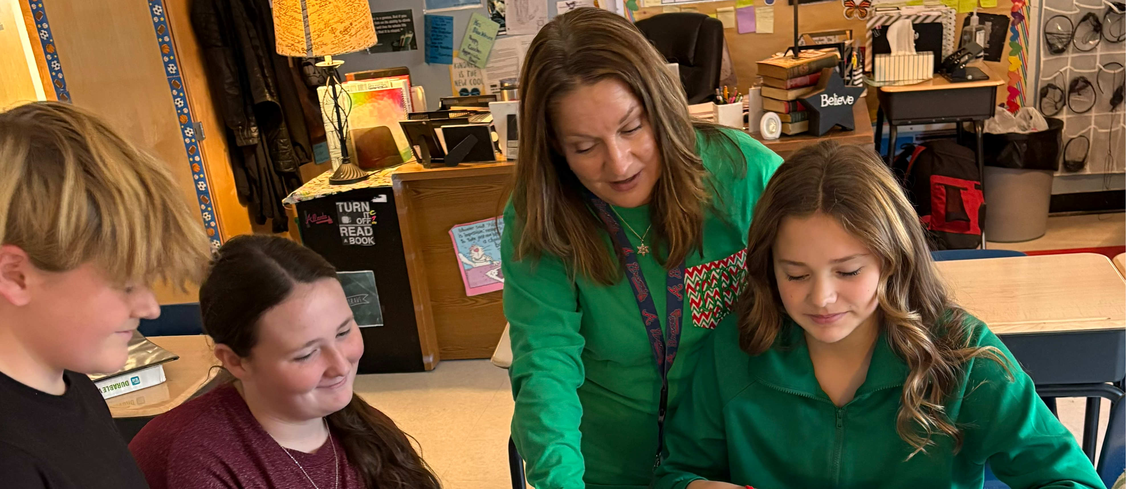 A teacher works with students in a classroom.