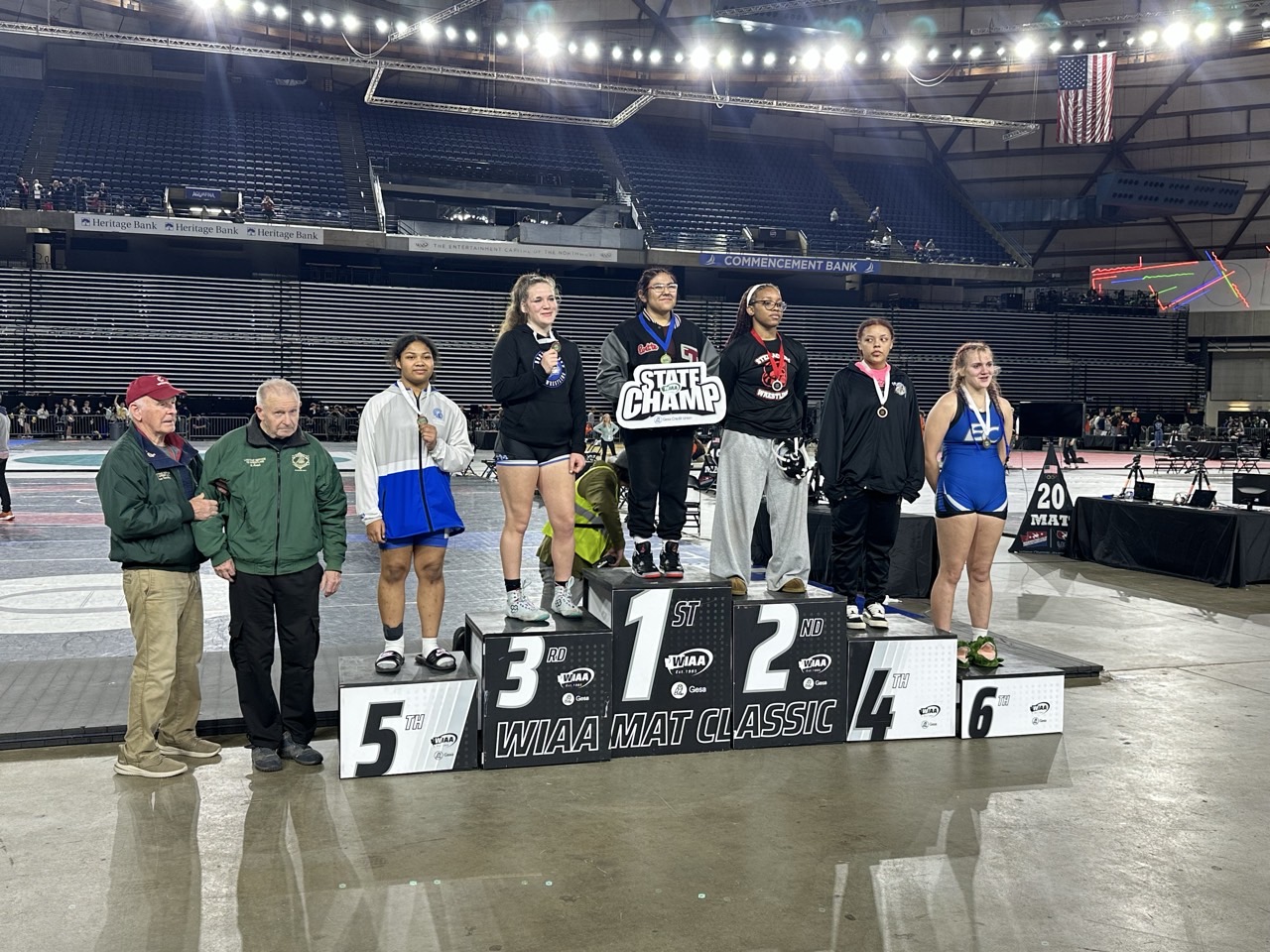 Students stand on platform at the WIAA Mat Classic state wrestling competition.