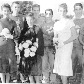 guys and girls taking a picture holding flowers