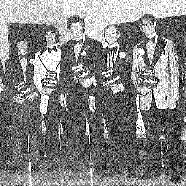 8 people standing holding a sign