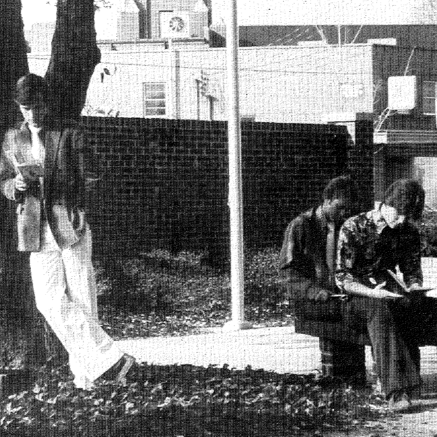 3 people sitting and reading. one person standing a reading