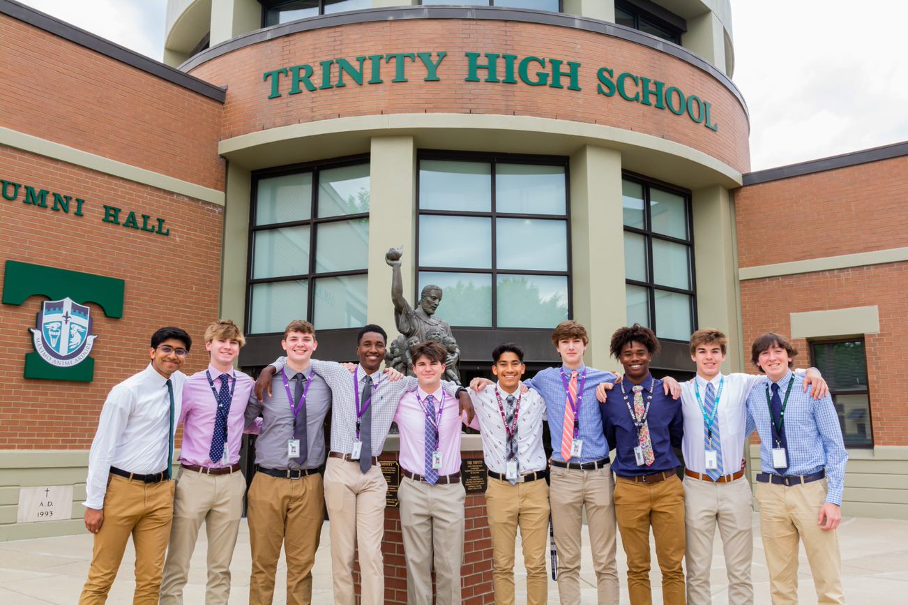 group of students getting a picture taken in front of Trinity High School