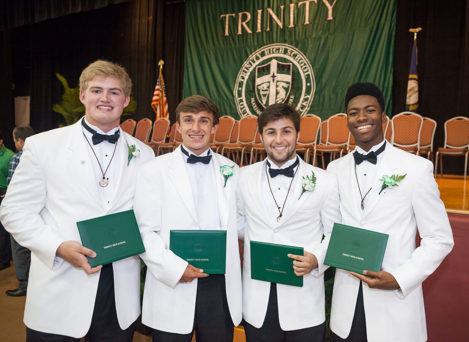 4 students holding their diplomas
