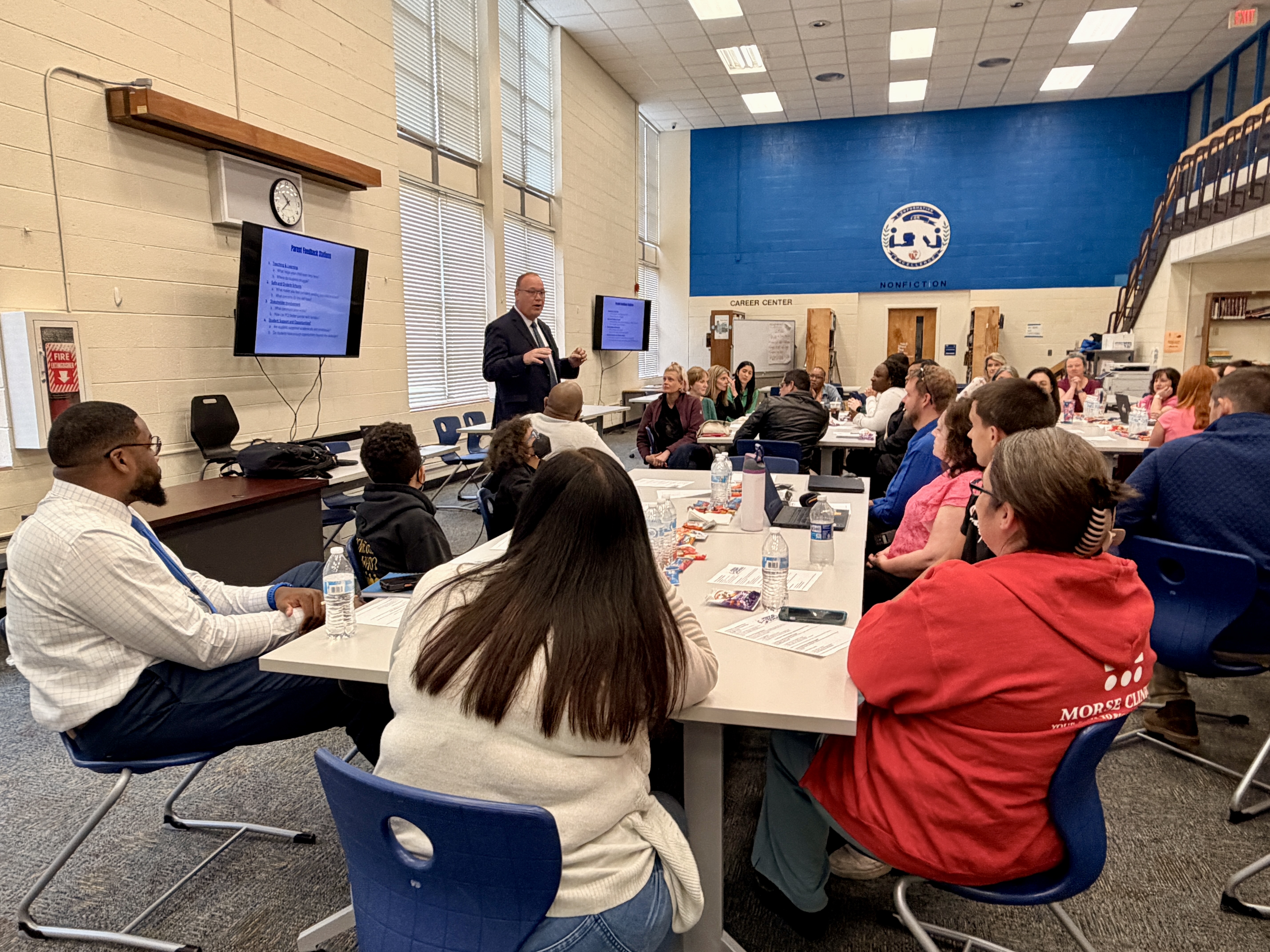 Picture of Dr. Peterson talking to group of administration, teachers, parents and students at PHS for strategic planning