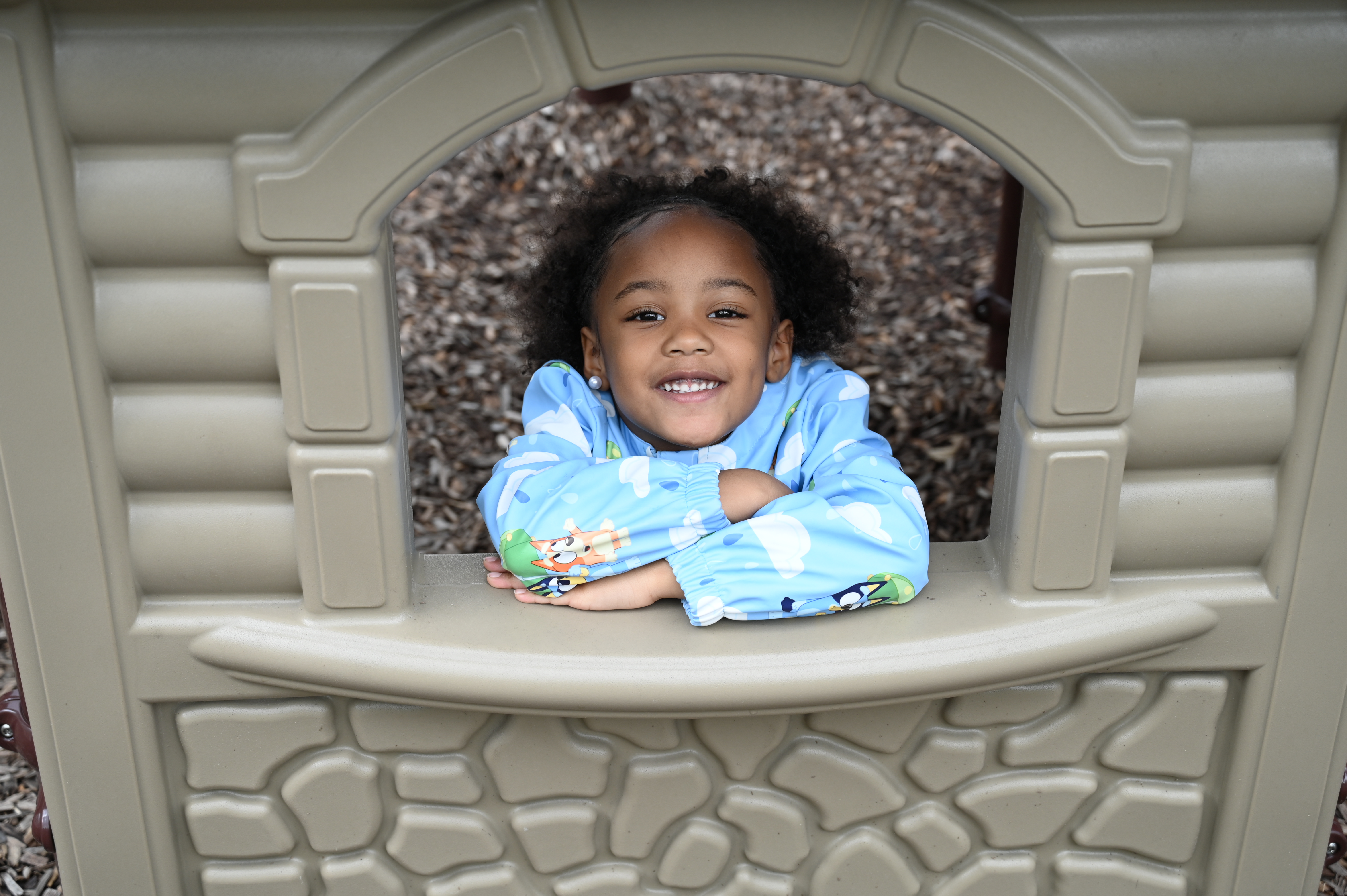 one black female student playing in the play house 