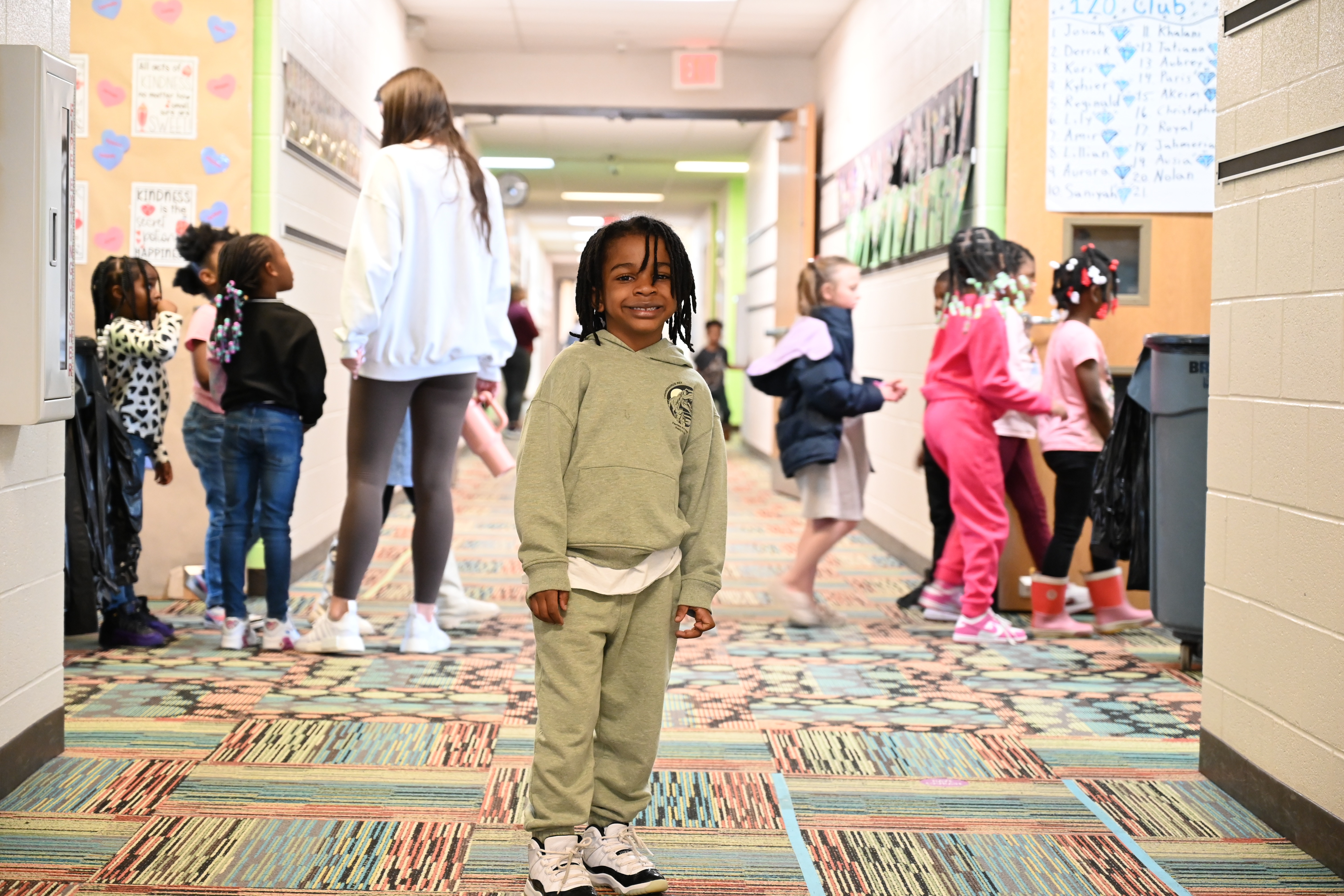 student standing in the hallway with other students switching class