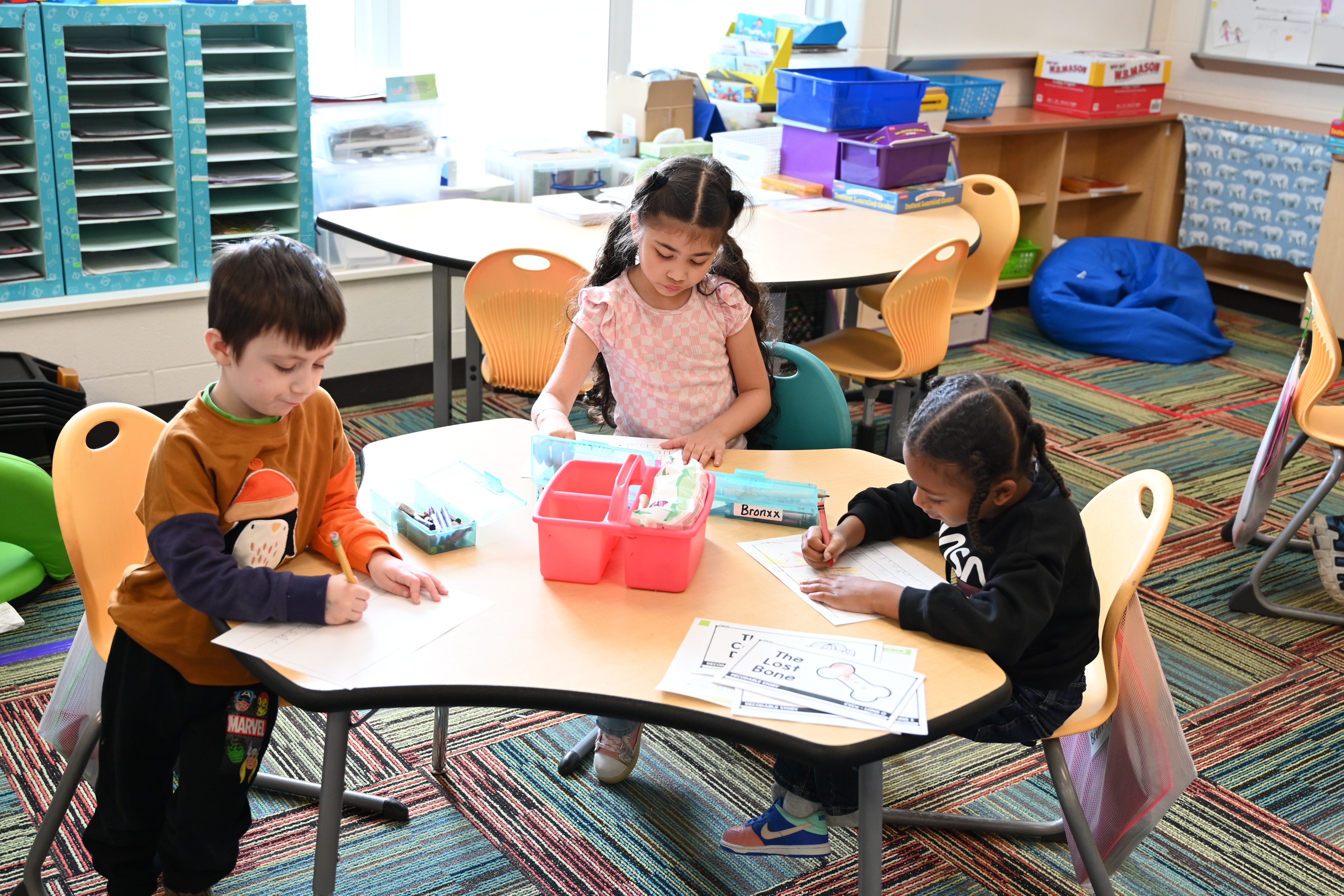 Students in the classroom working together writing and coloring 