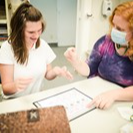 Student and teacher at a table learning together.