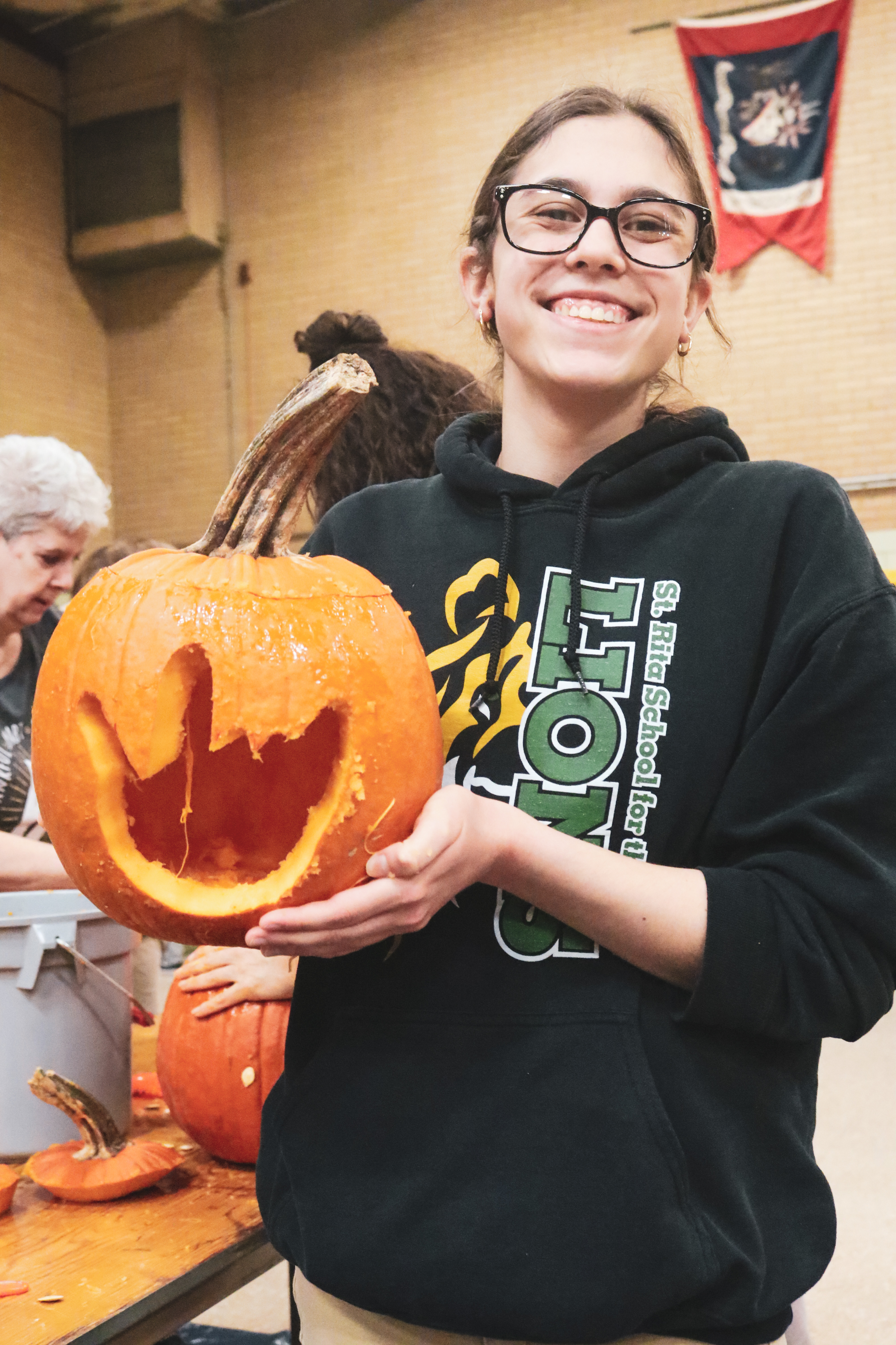 a female high school with carved pumpkin