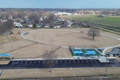 ariel view of Colonial Park with walking trail, pickle ball courts, pump track, dog park and playground equipment