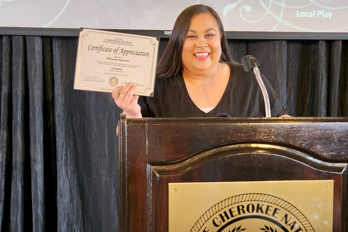 Whitney Sanders holding Certificate of Appreciation from the Cherokee Nation