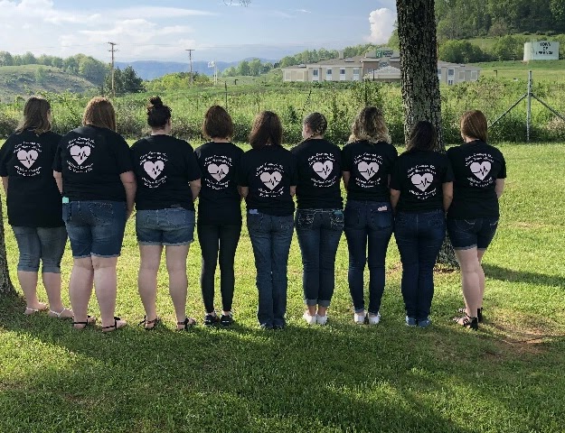 CNA students showing the back of their shirts