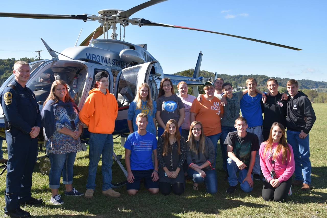 Pictures of students in front of a helicopter